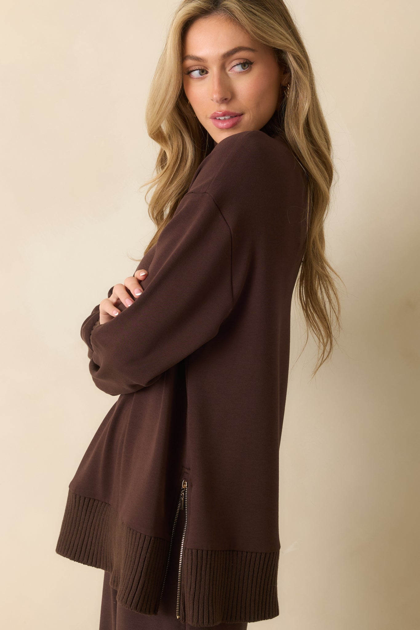 A cropped side image emphasizing the long sleeve fit and side zipper detail.