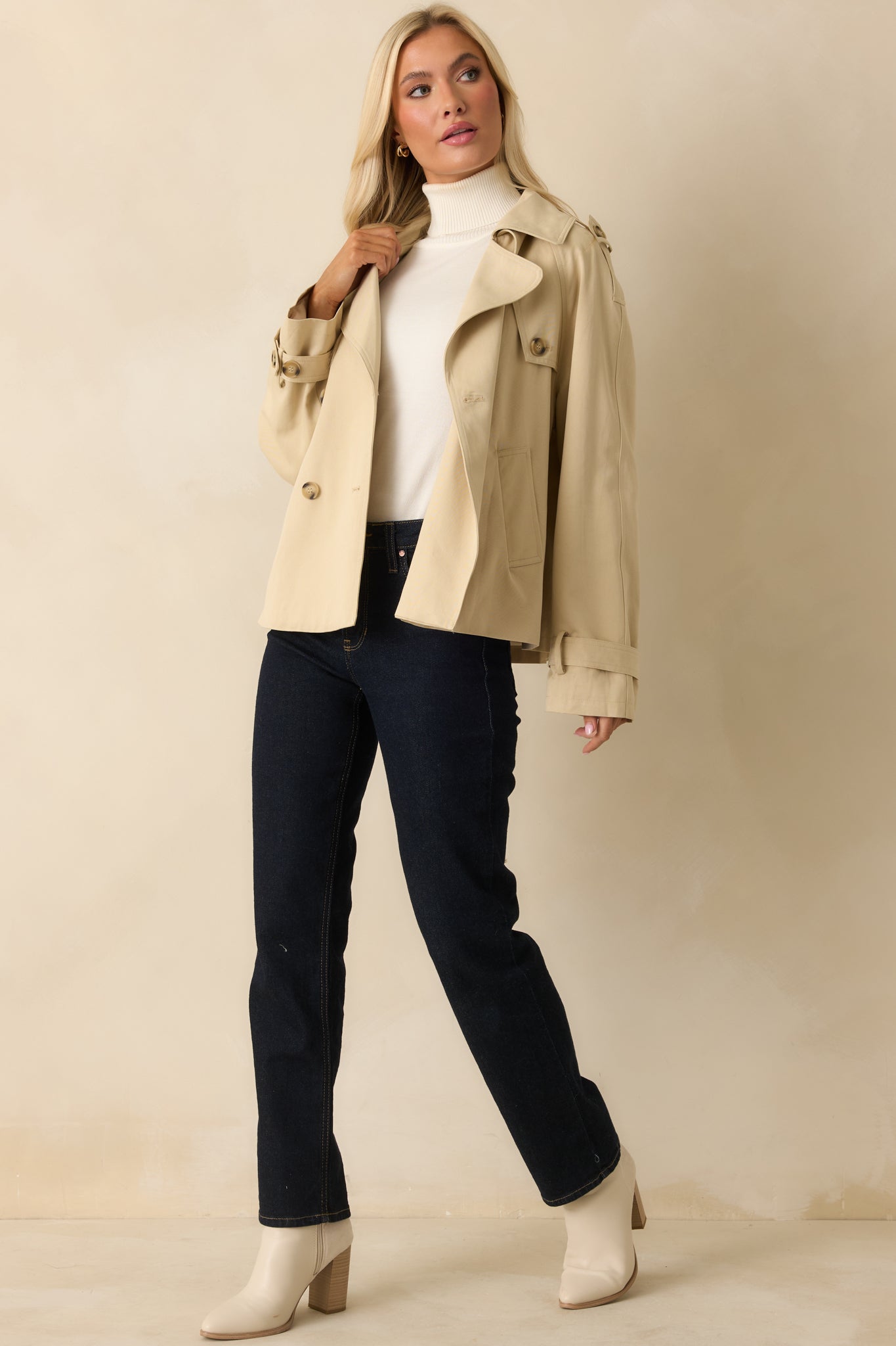 Cropped trench jacket featuring button-tab cuffs and functional side pockets in a relaxed silhouette.
