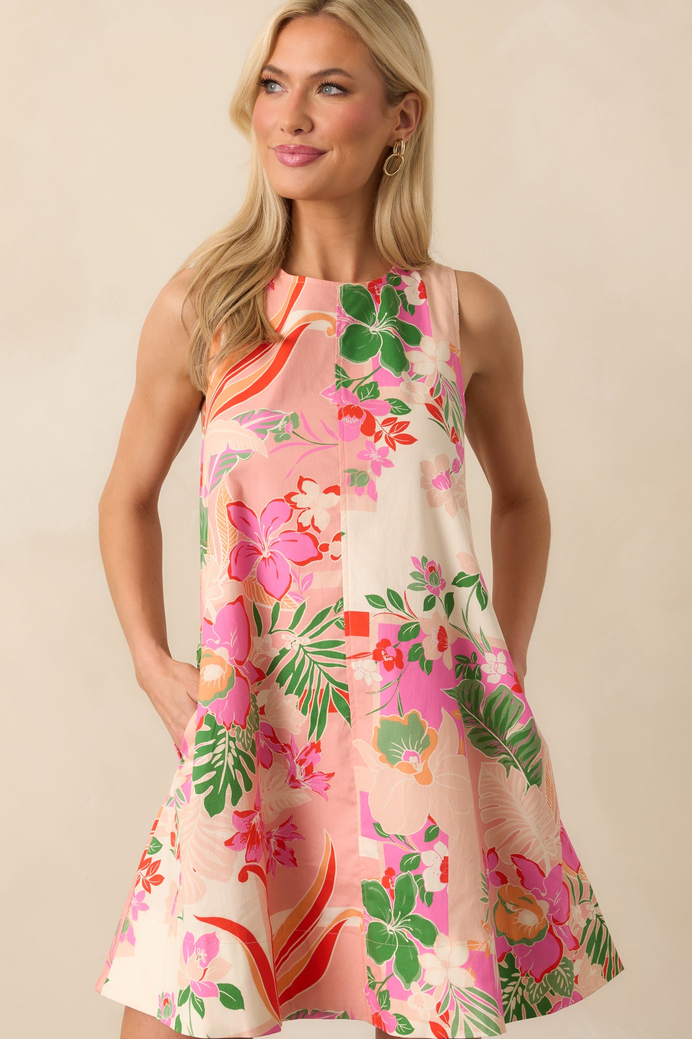 Cropped view of the upper bodice showing the round neckline and tropical print of the pink mini dress.