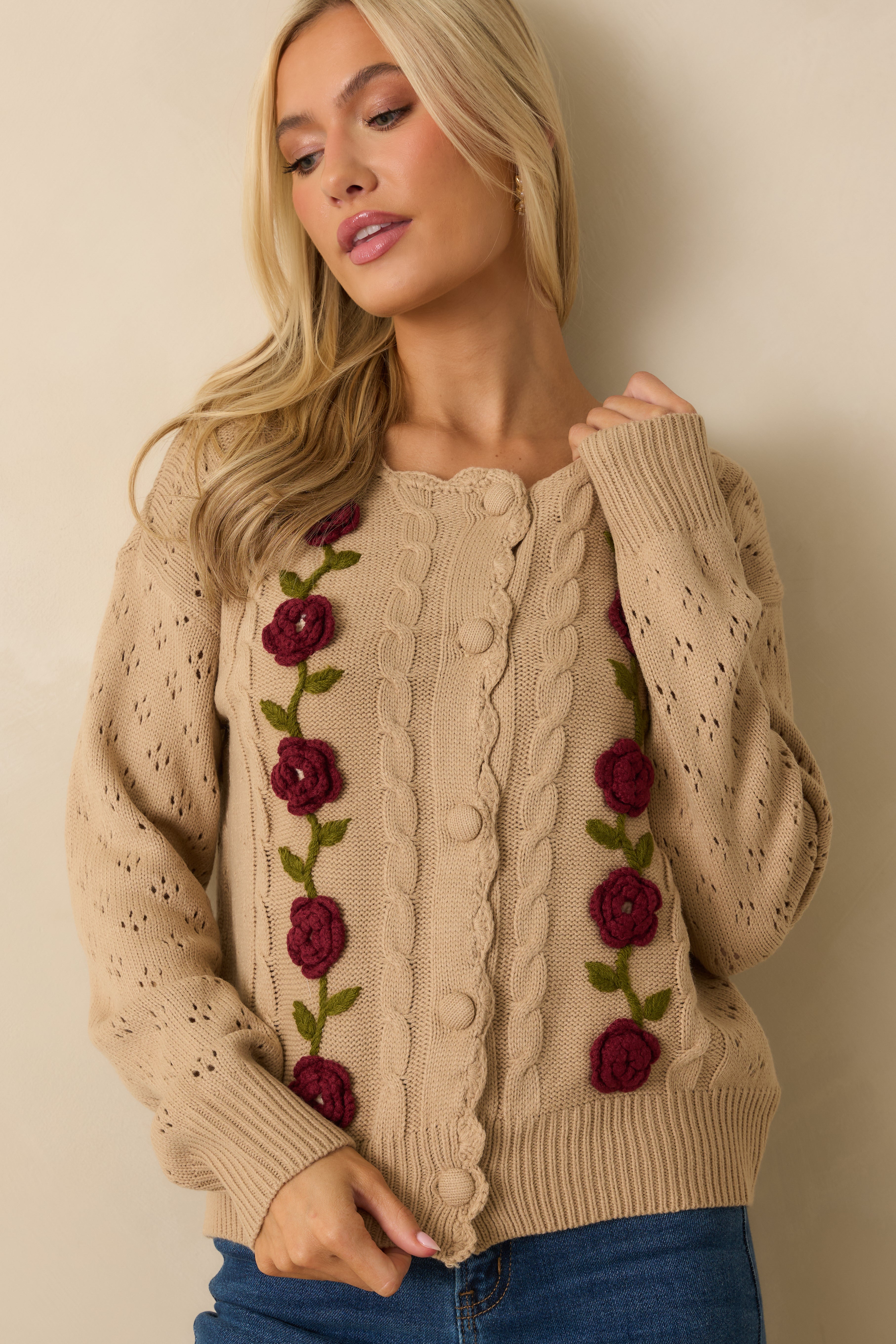 Cropped upper view focusing on the neckline, buttons, and cable-knit front.