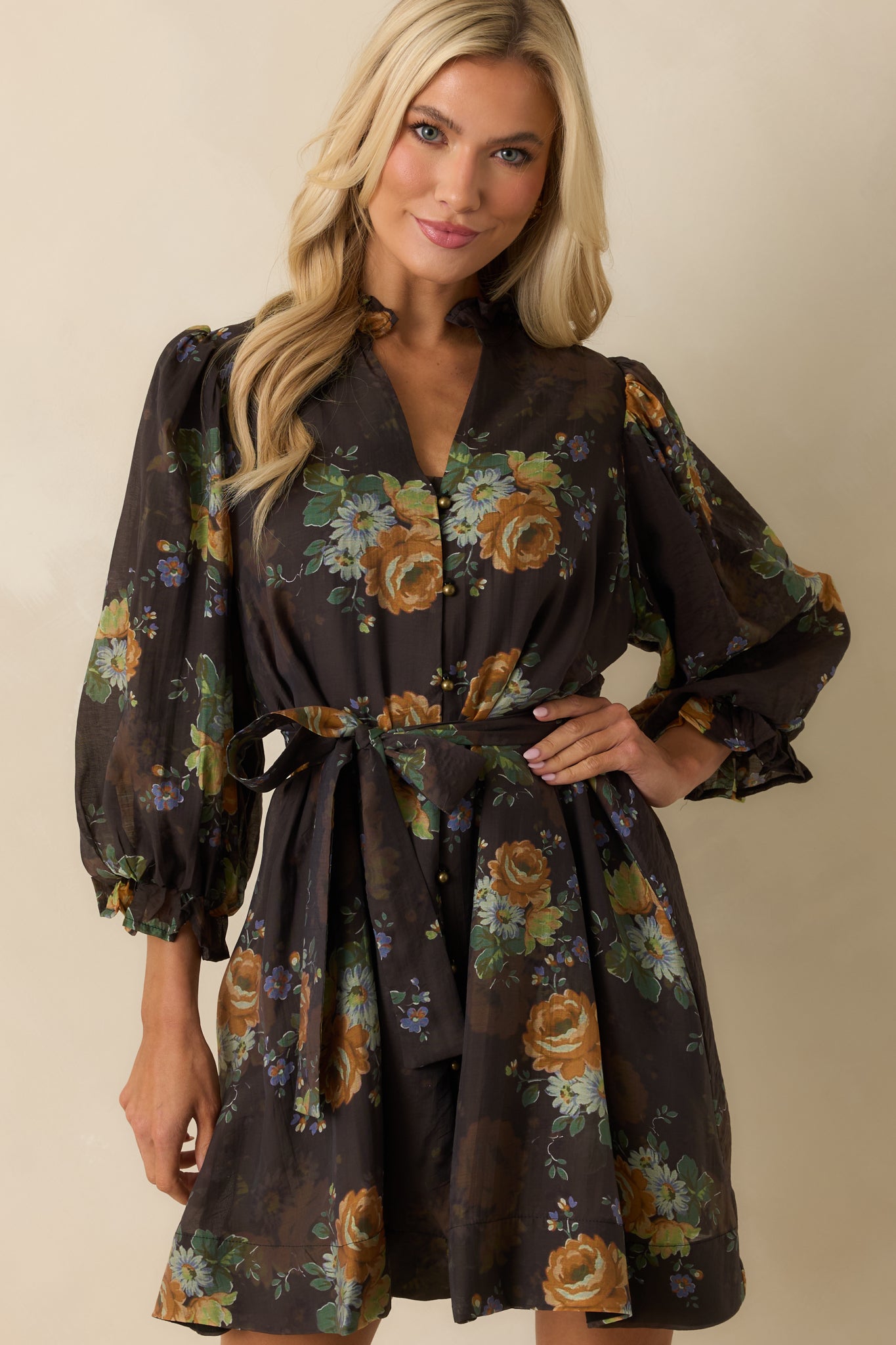 Cropped view emphasizing the puff sleeves and ruffled cuffs on the brown floral mini dress.