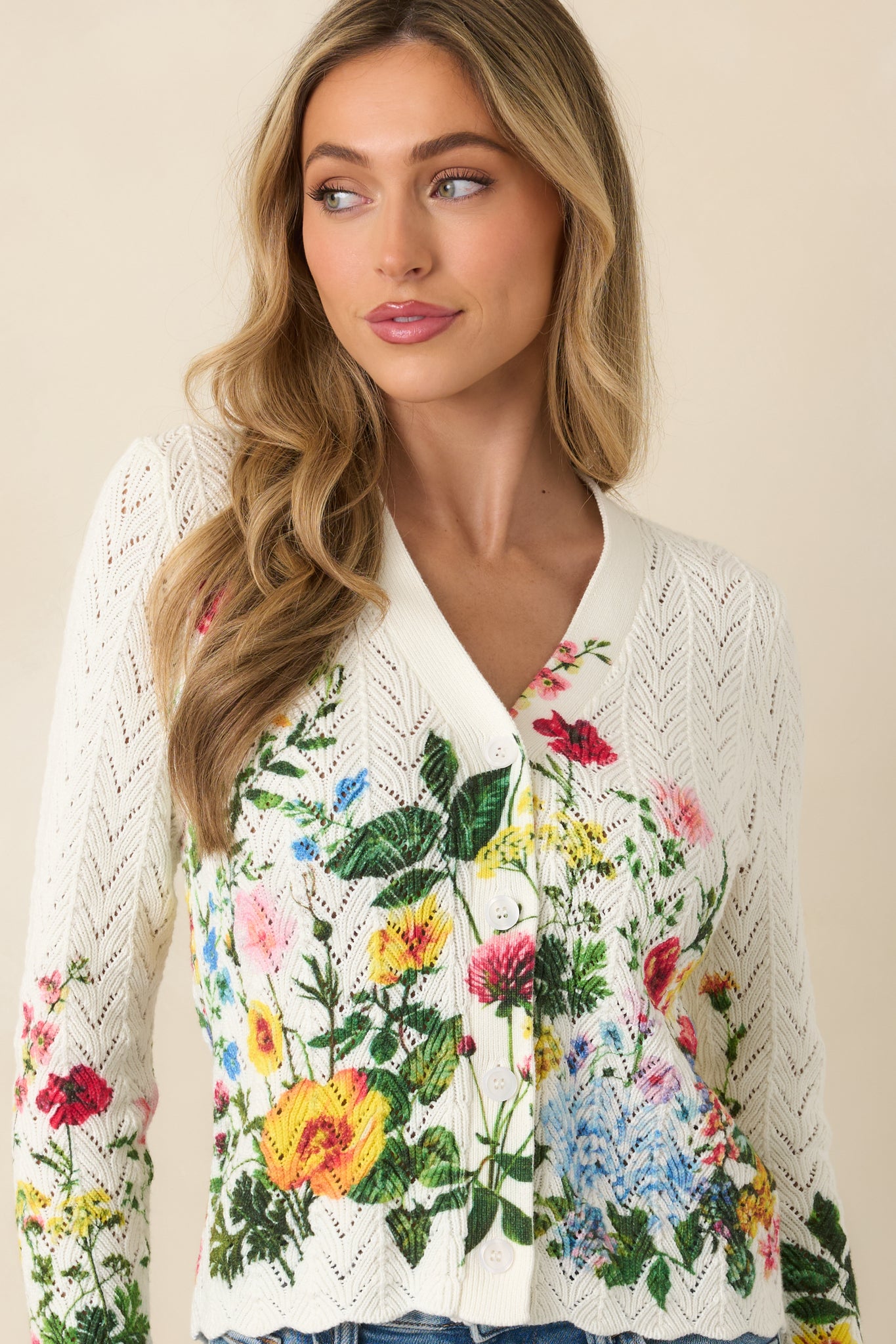 Detailed cropped view of the cardigan showcasing the allover openwork pattern and multicolor floral design.