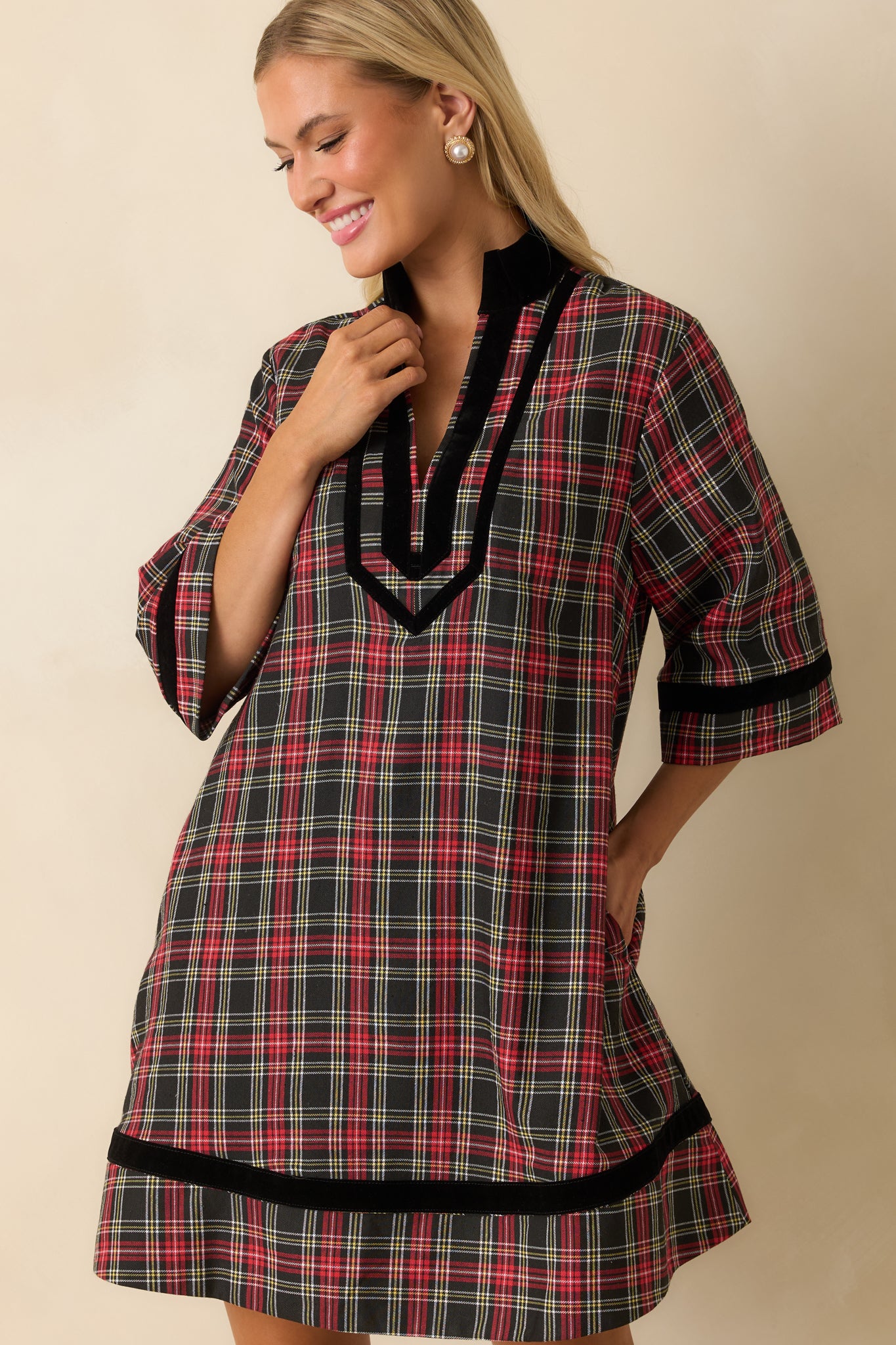 Crop highlighting elbow-length sleeves and the relaxed A-line silhouette of the red plaid dress.