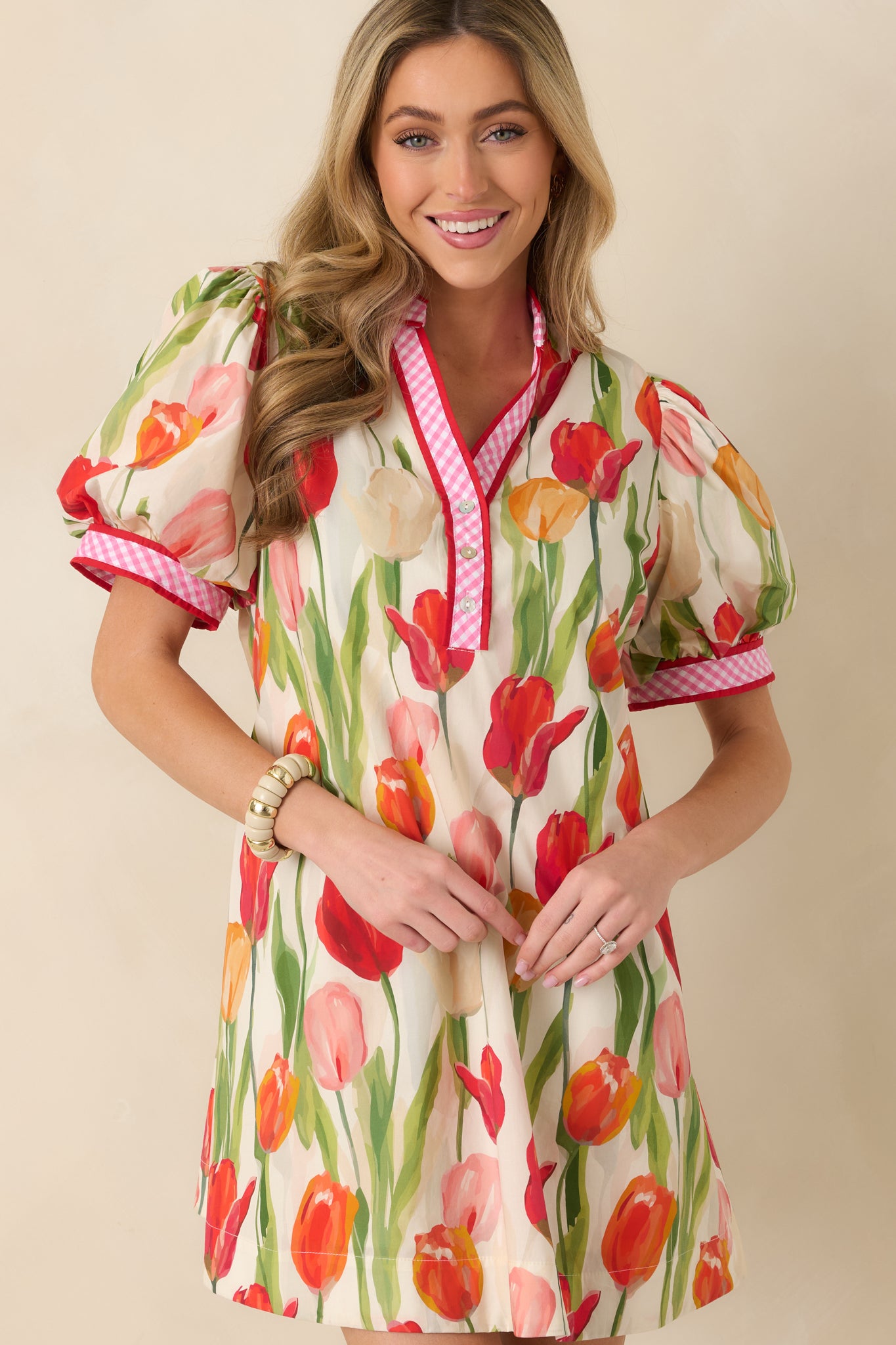Cropped front view focusing on the V-neckline and contrast red and pink gingham trim detail.
