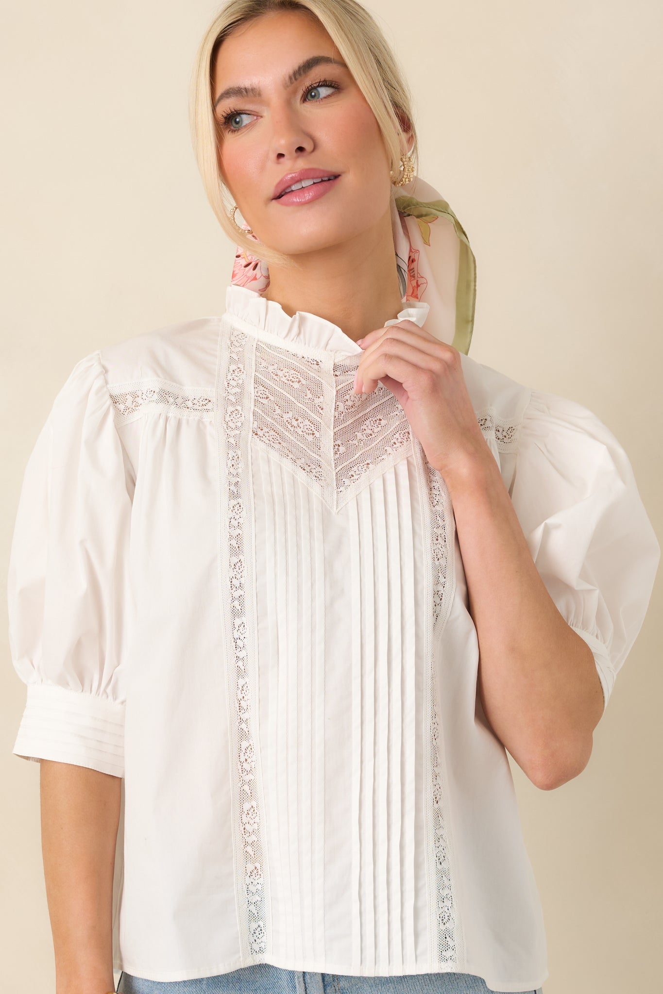 Cropped front view focusing on the ruffled high neckline and lace-trimmed pintuck detailing.