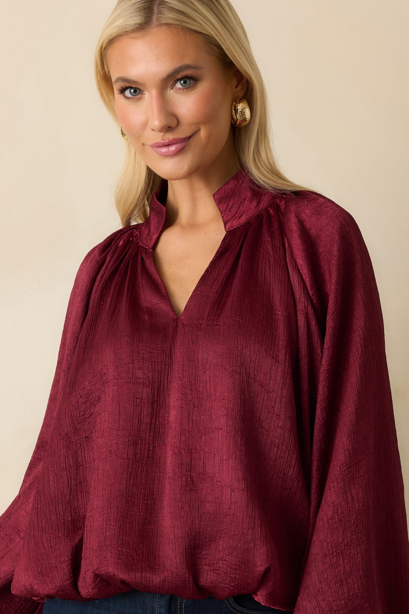 Crop highlighting the gathered cuffs and flow of the long peasant sleeves.