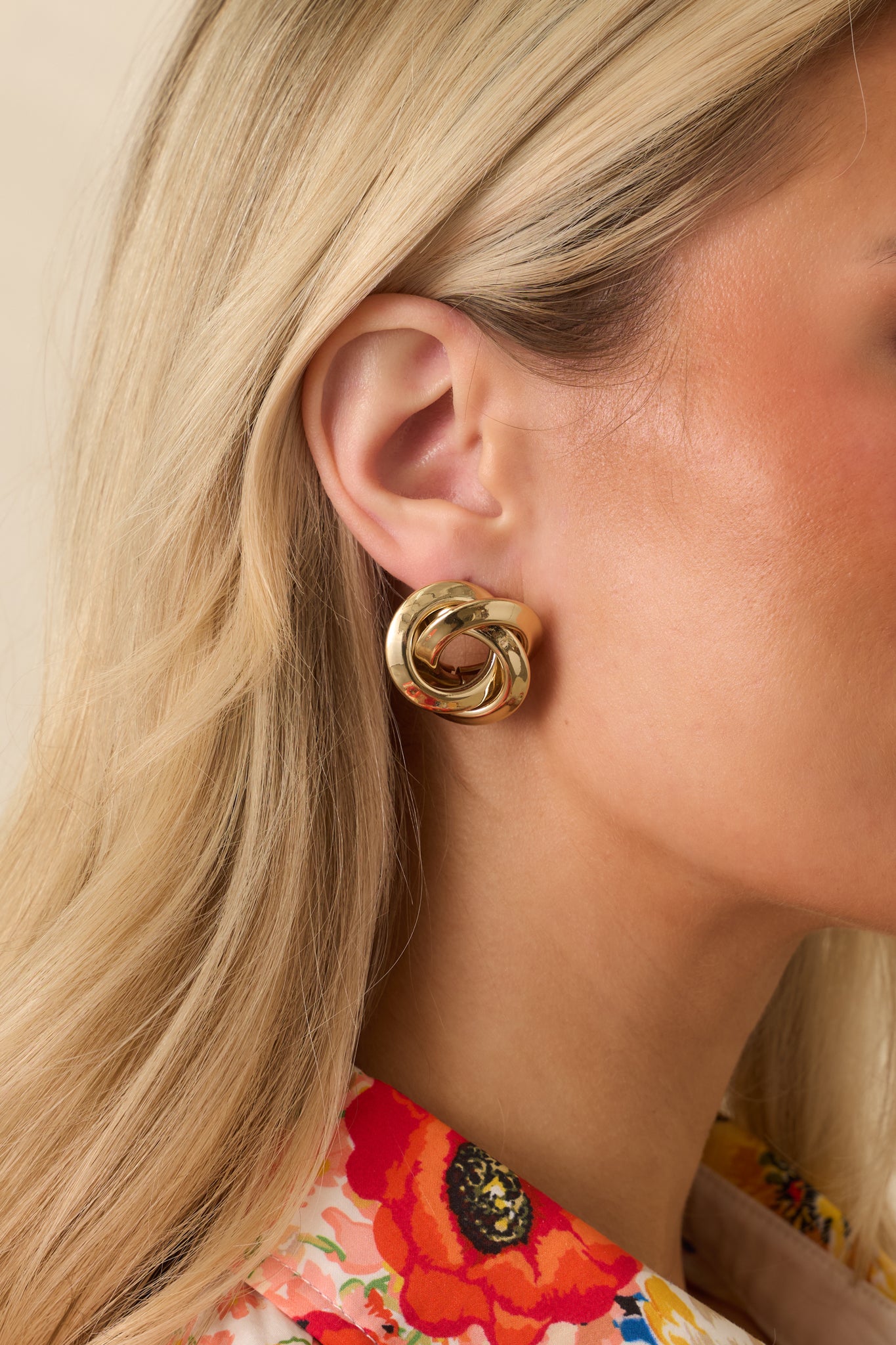 Cropped view of gold twisted spiral earrings showing hollow center and smooth polished surface.