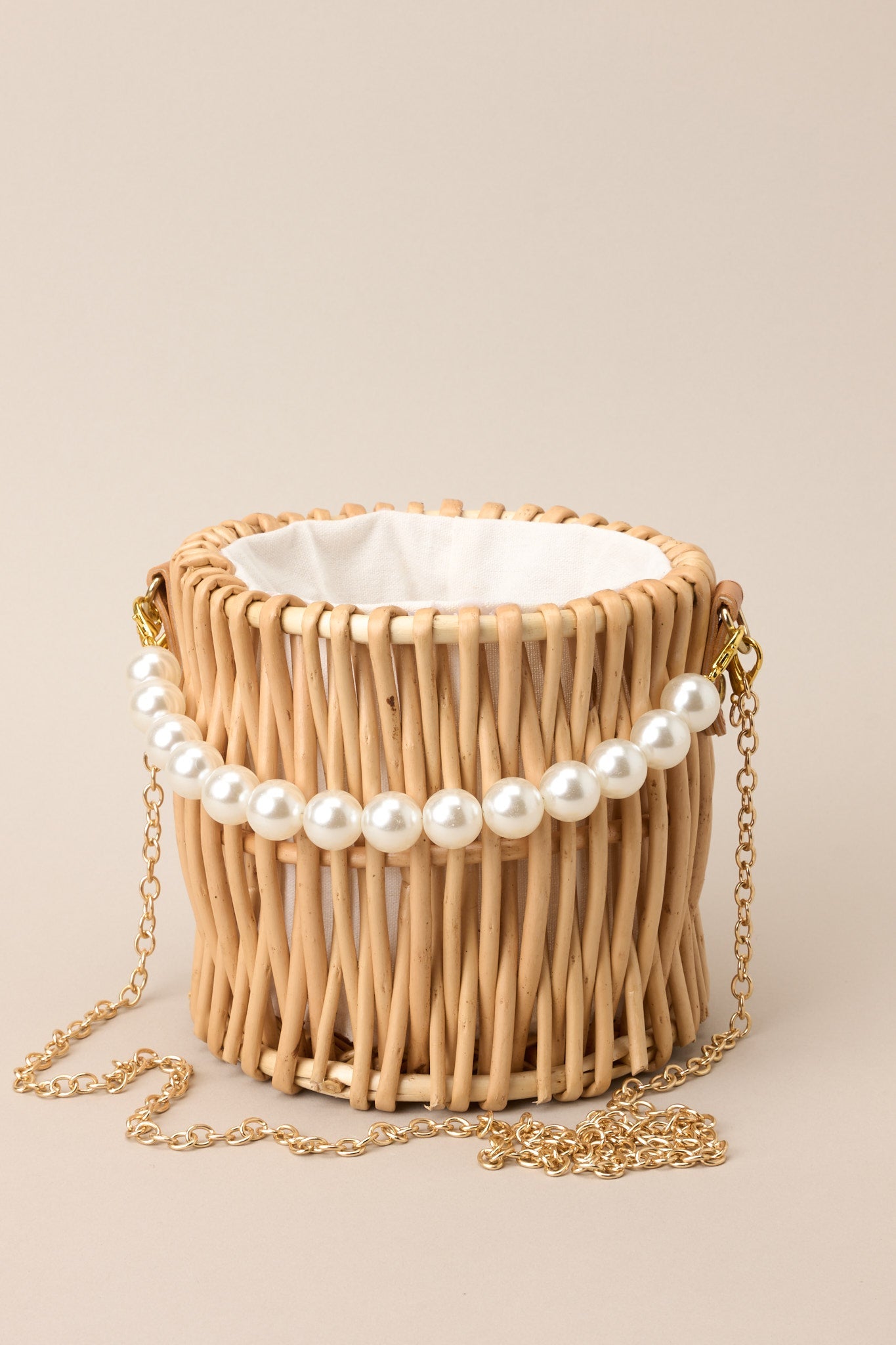 Cropped view highlighting woven wicker texture, structured silhouette, and gold hardware accents.