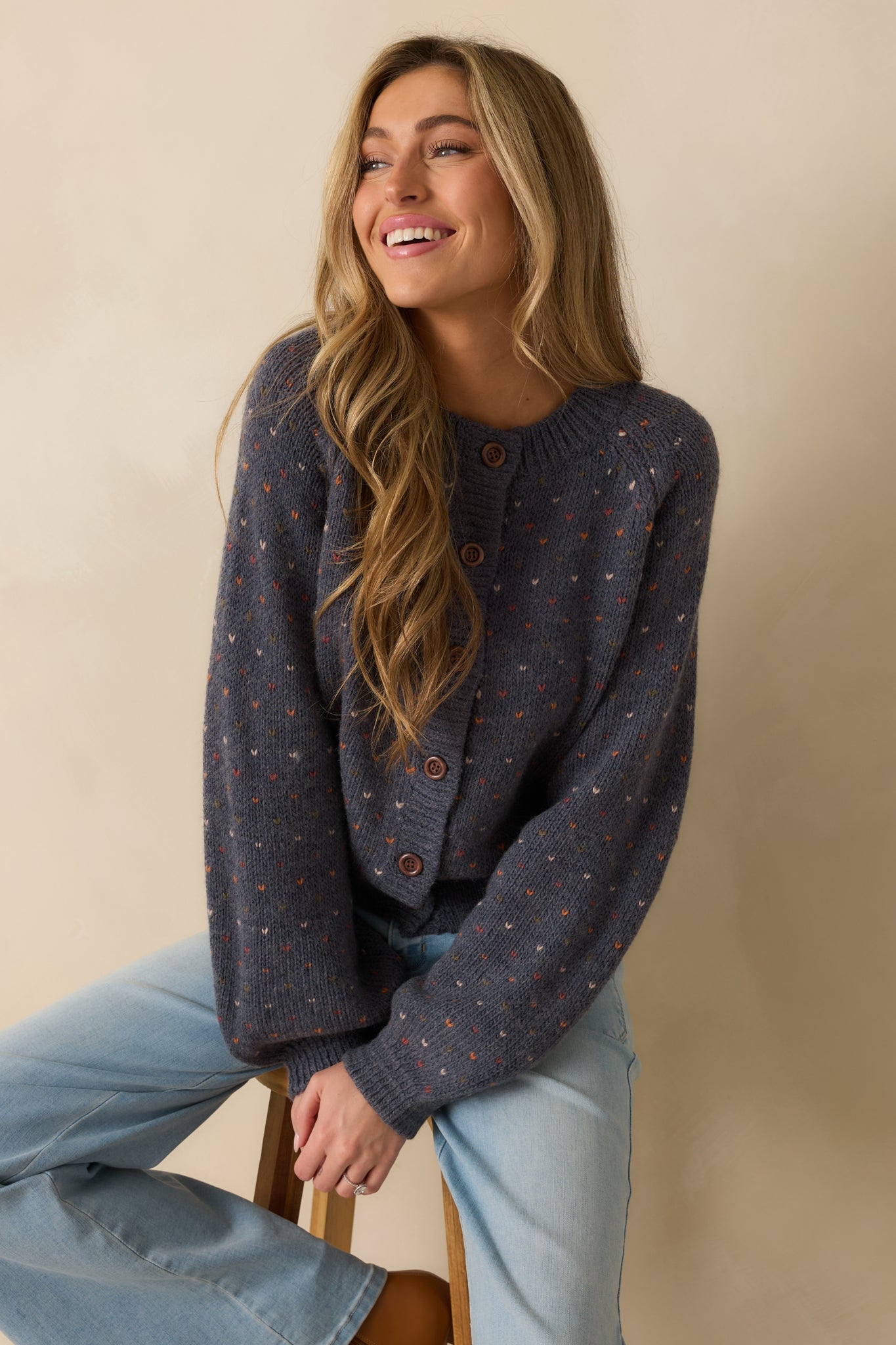 Cropped view focusing on the heart-accented buttons and textured wool blend knit.
