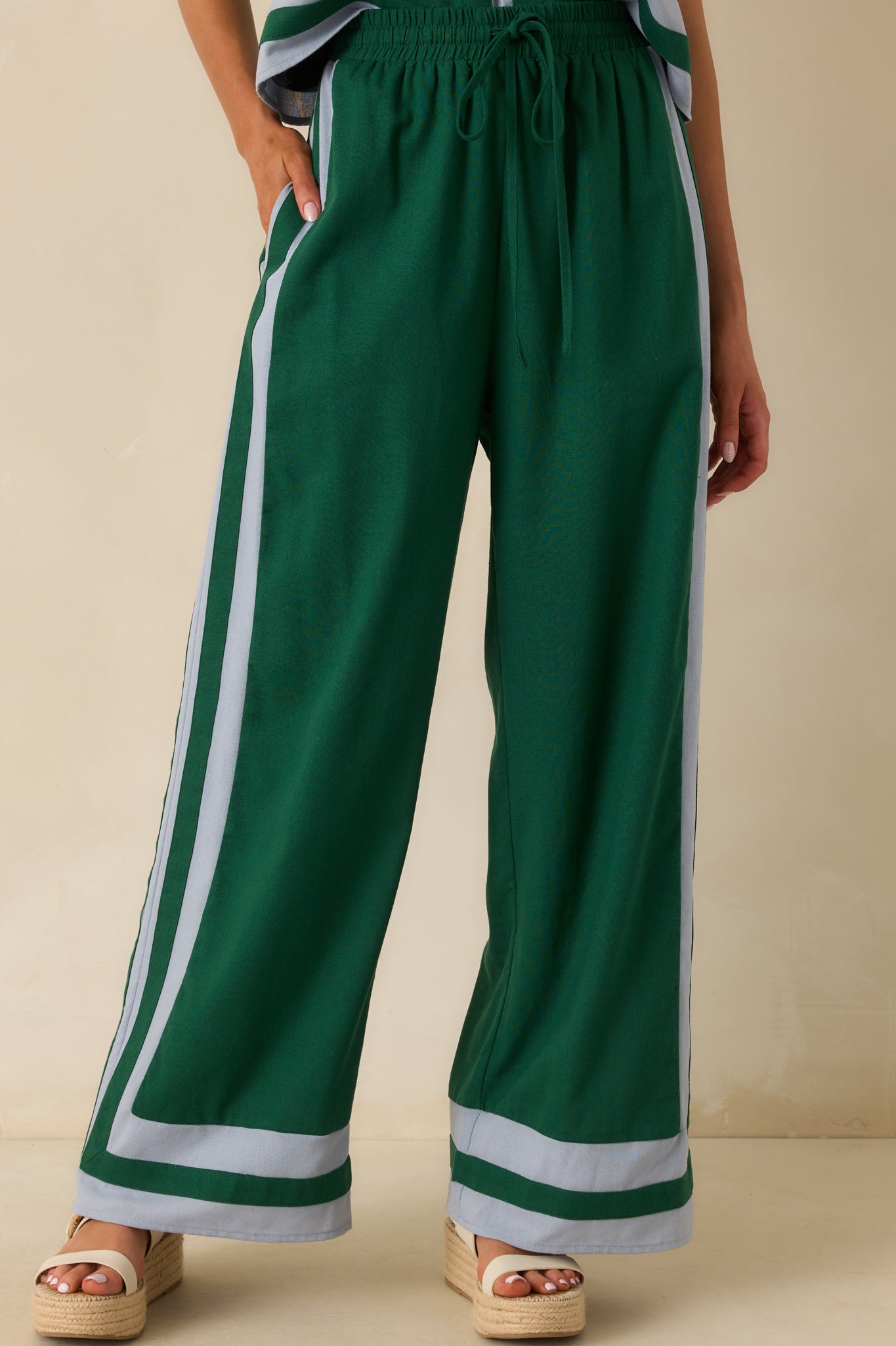 Cropped view highlighting the light blue trim running down the pant legs and the smooth fabric texture.