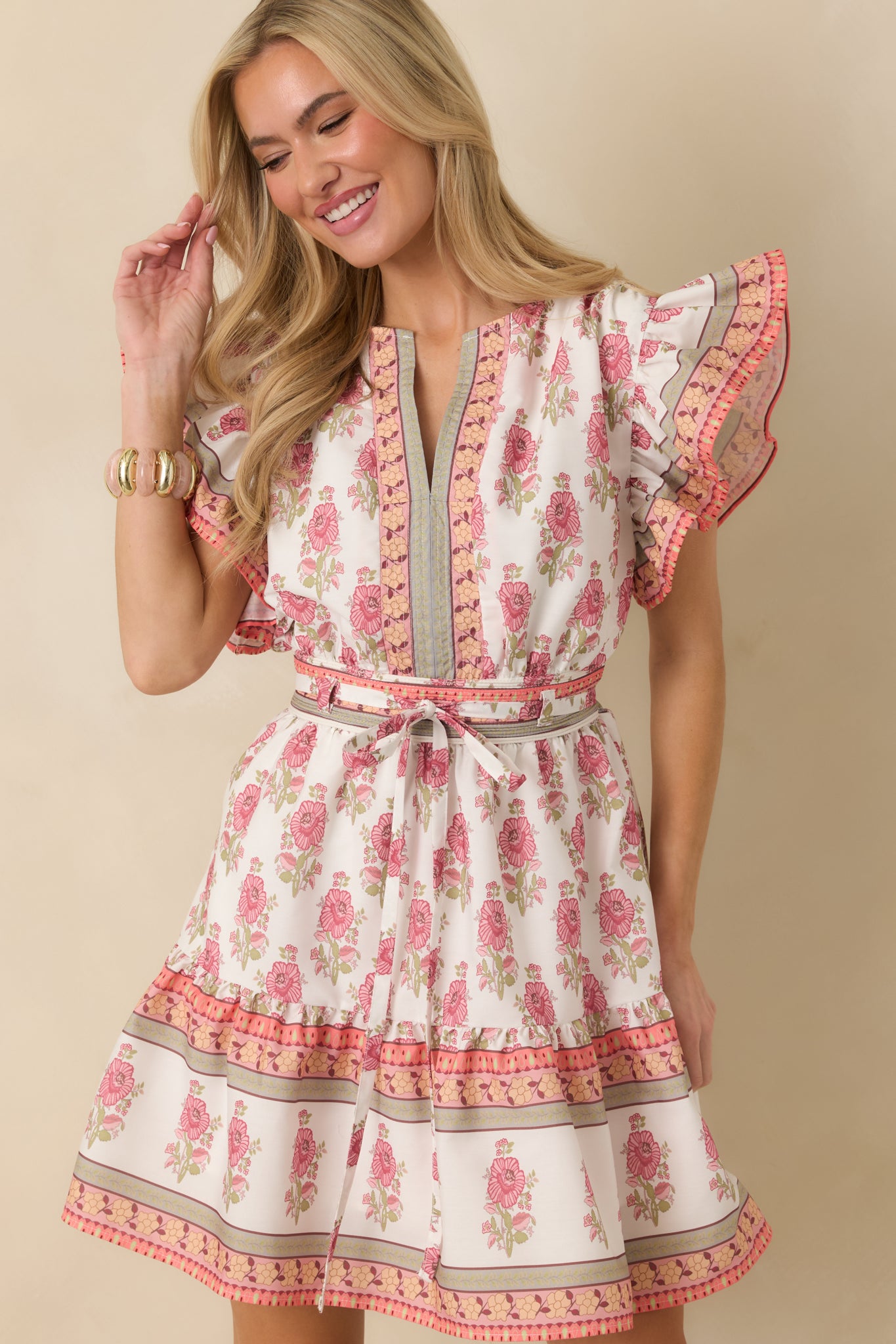 Close-up cropped view of the dress highlighting the tiered hem with orange and green trim and lightweight floral fabric.