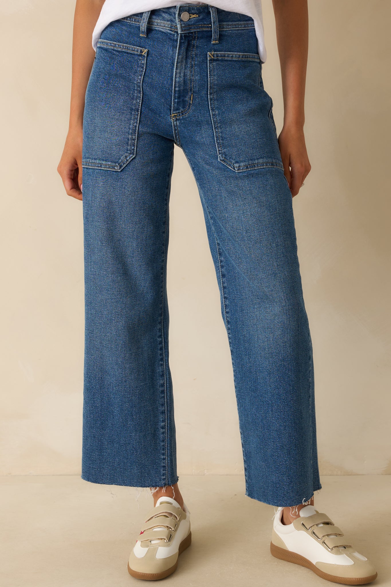 Cropped view highlighting the front patch pockets and smooth denim texture.