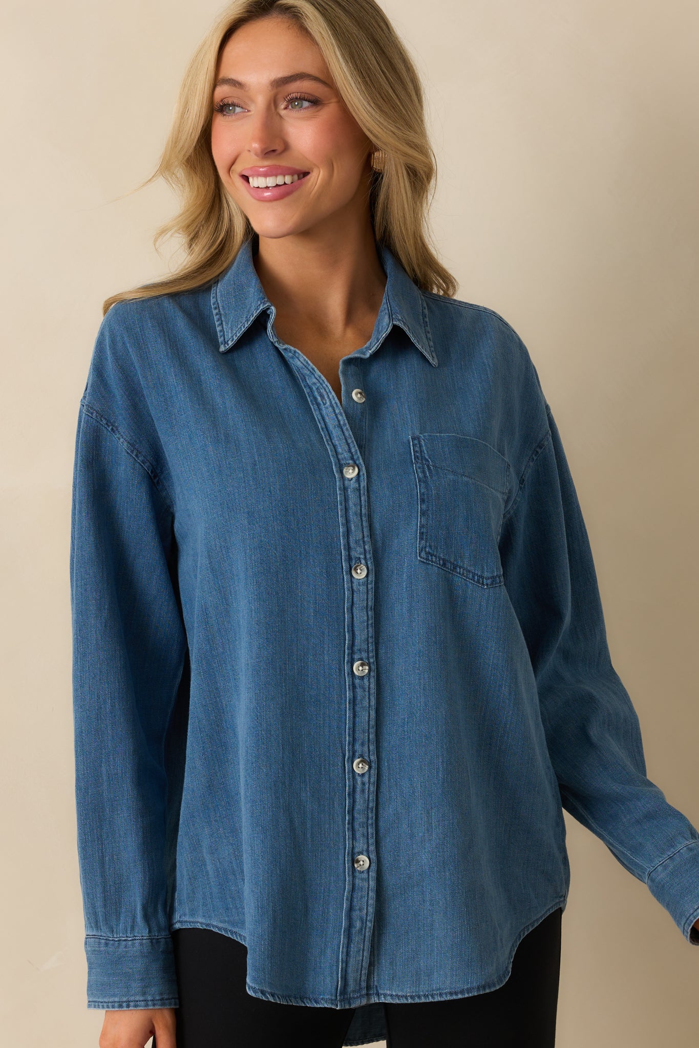 Cropped view showing the long sleeves and button details of the medium wash top.