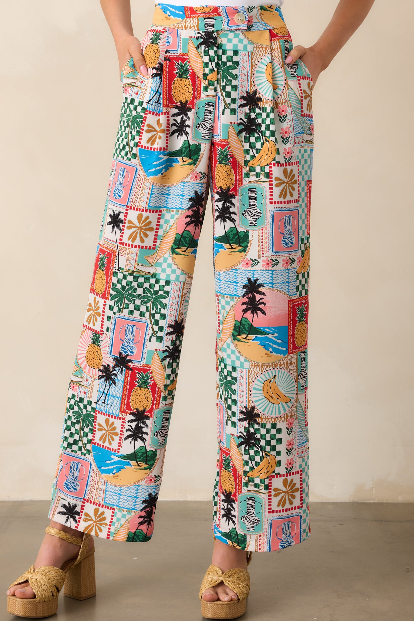 Cropped view of tropical pants emphasizing the waistband with beige button and zipper closure.