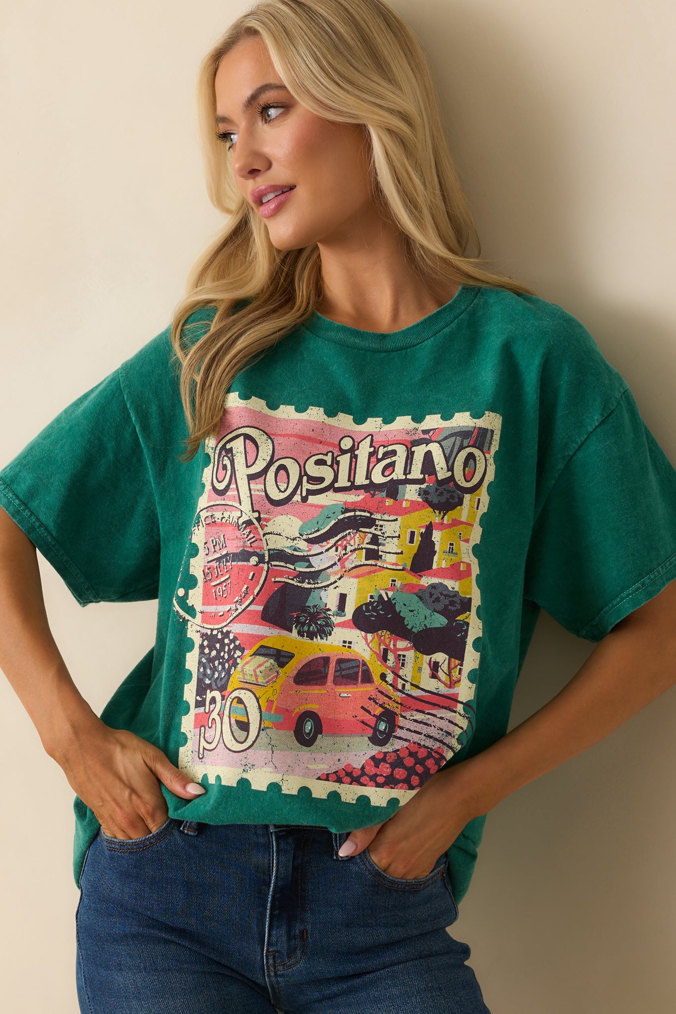 A cropped front view focusing on the Positano postage stamp graphic on the chest of the green tee.