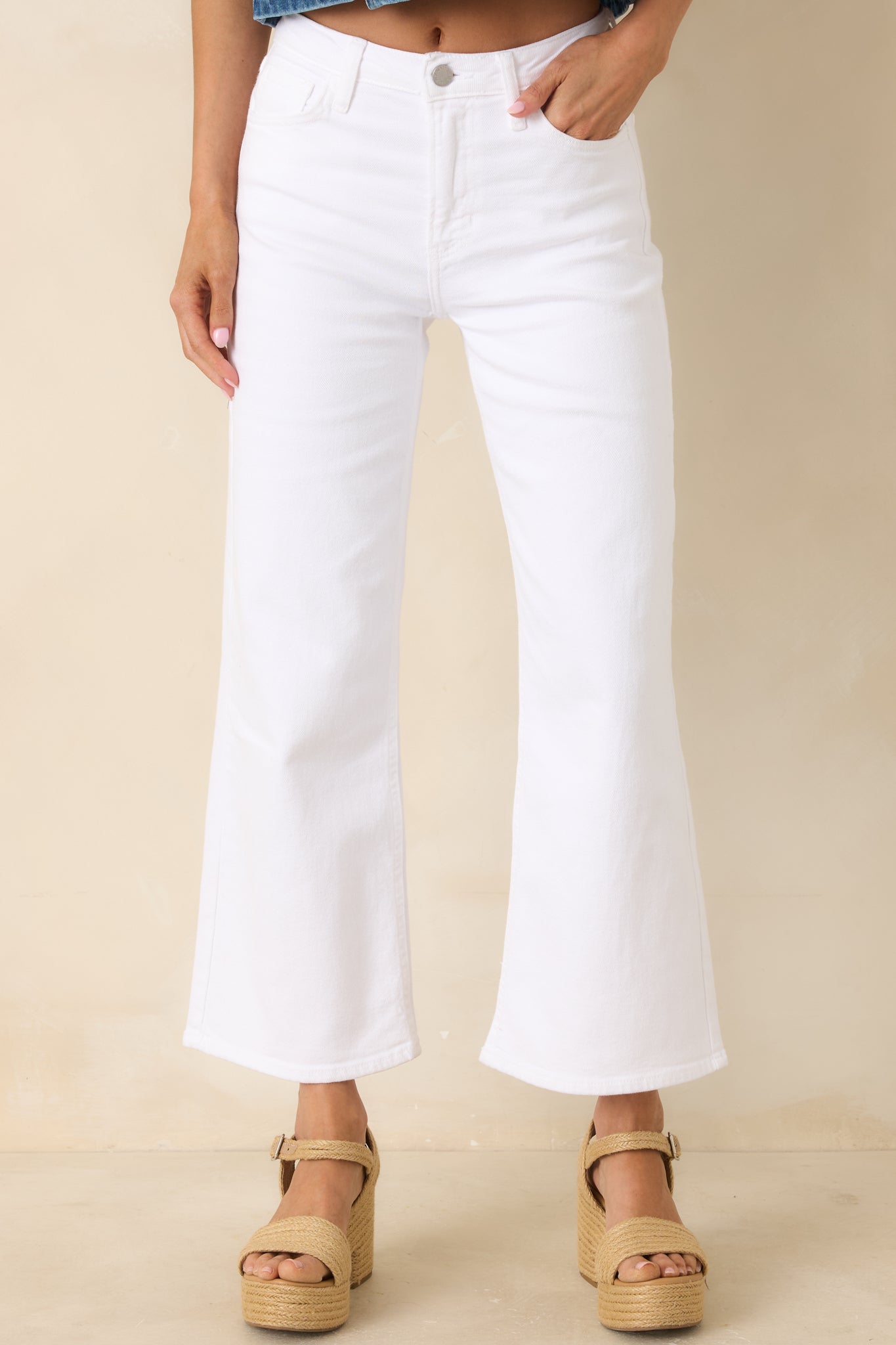 Cropped view of white denim jeans highlighting the high-rise waist and wide leg opening