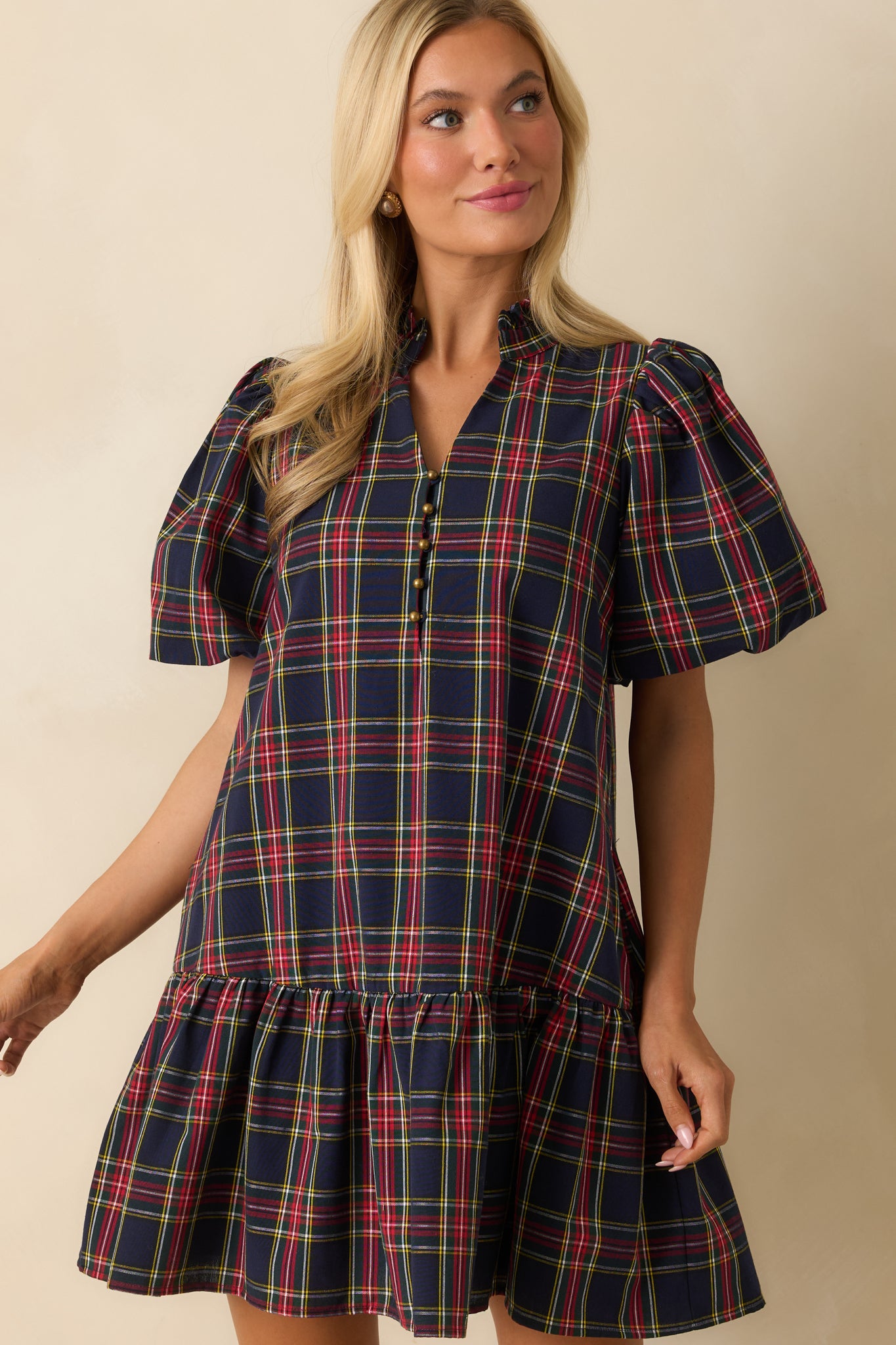 Cropped view showing short puff sleeves, buttoned neckline, and textured plaid fabric on the navy mini dress.