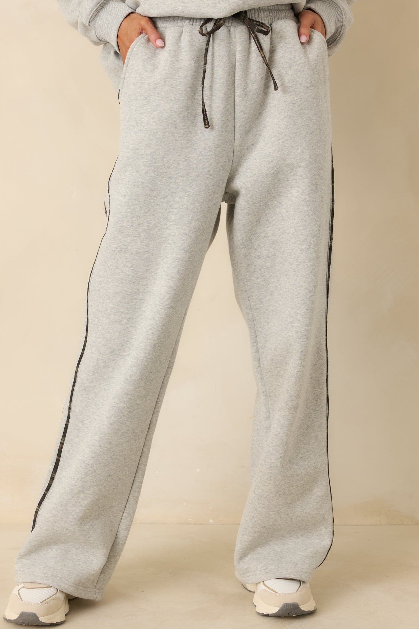 Cropped view showing soft knit texture and side stripe accents on grey sweatpants.