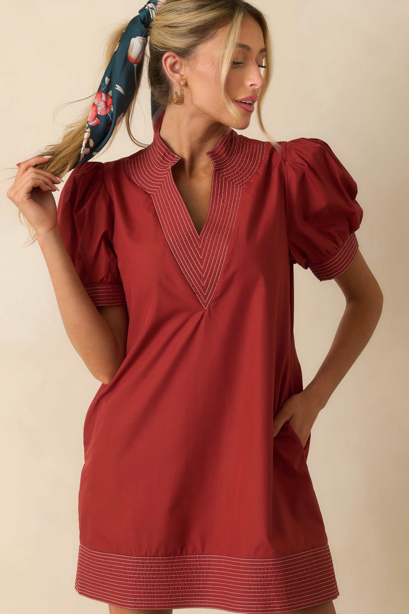 Cropped view showing the textured fabric and subtle seam detailing on the brick red dress.