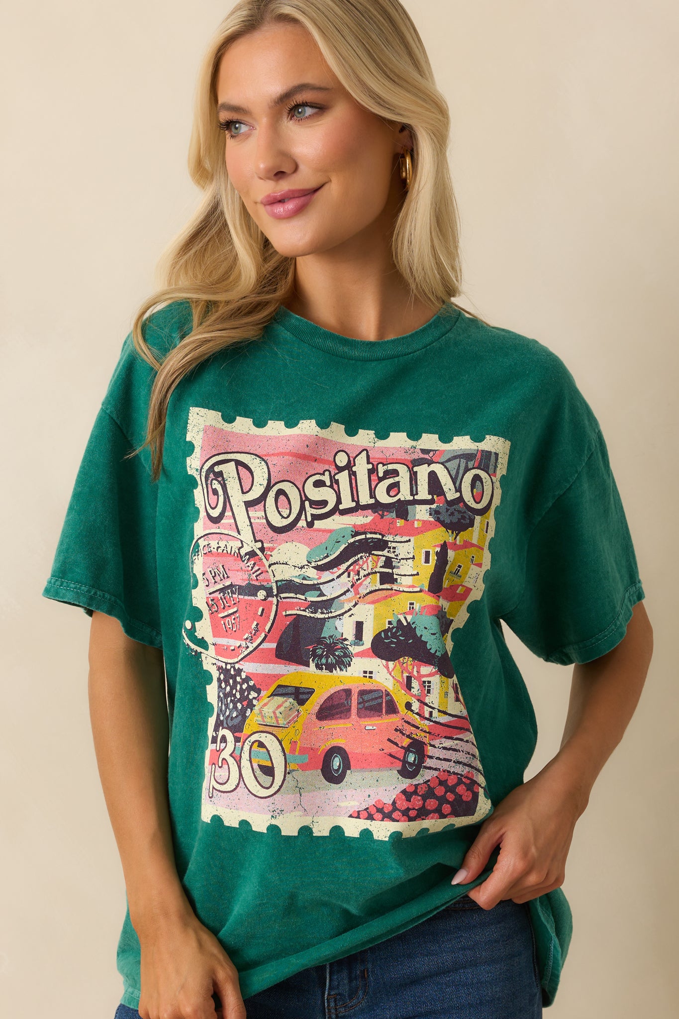 A cropped waist-up view emphasizing the front graphic and soft green acid wash color.