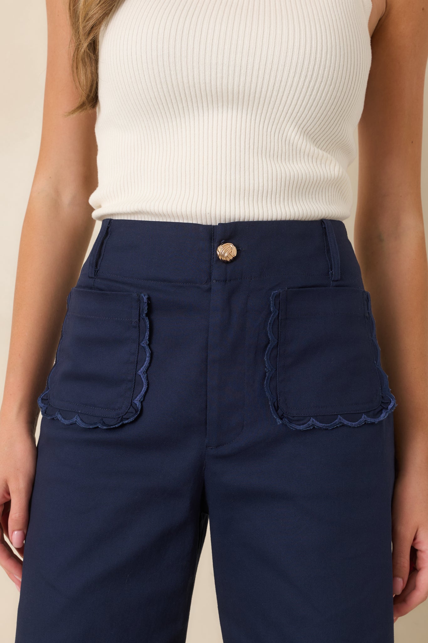Structured wide-leg pants with a flattering cropped fit, feminine scalloped pocket trim, and refined gold-tone button detail.
