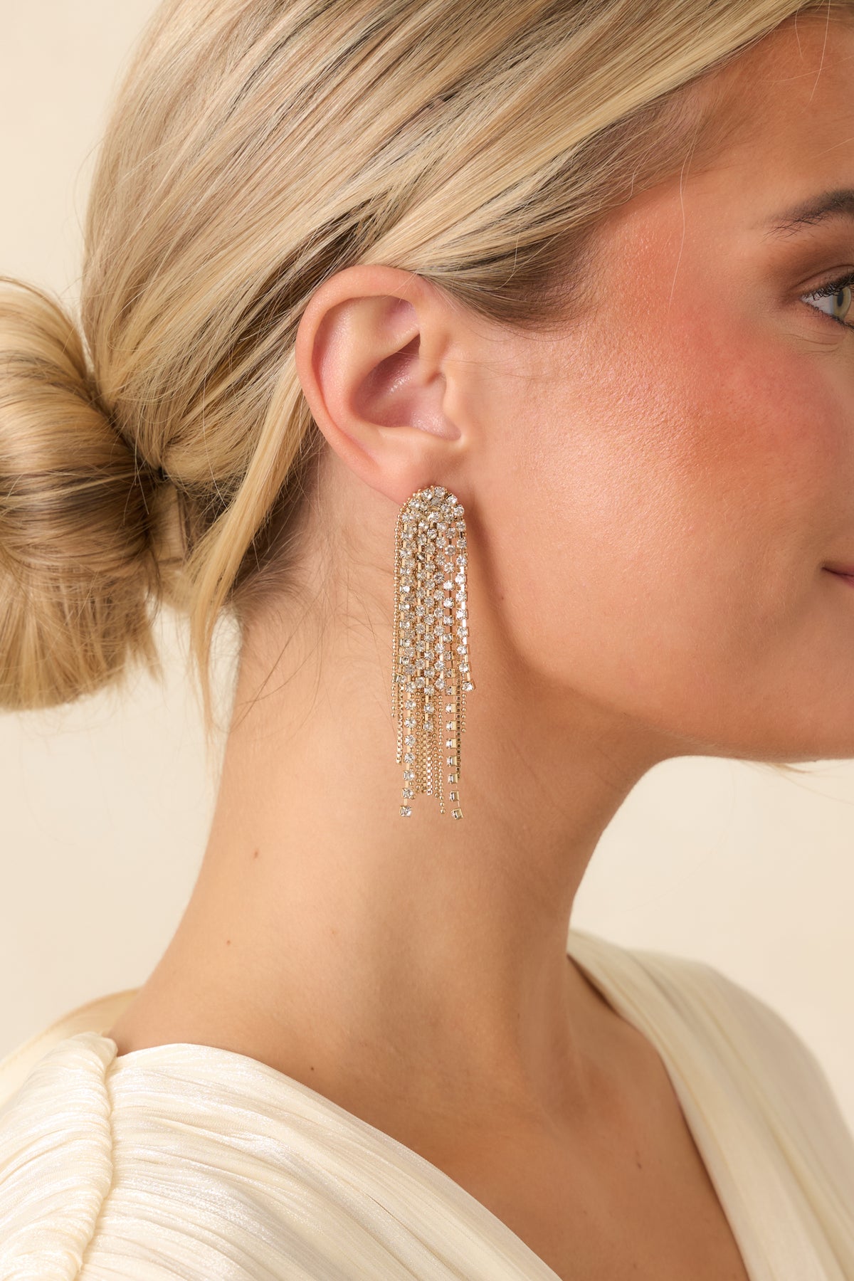 Sparkling waterfall earrings featuring rounded crystal studs and layered rhinestone strands in varying lengths.