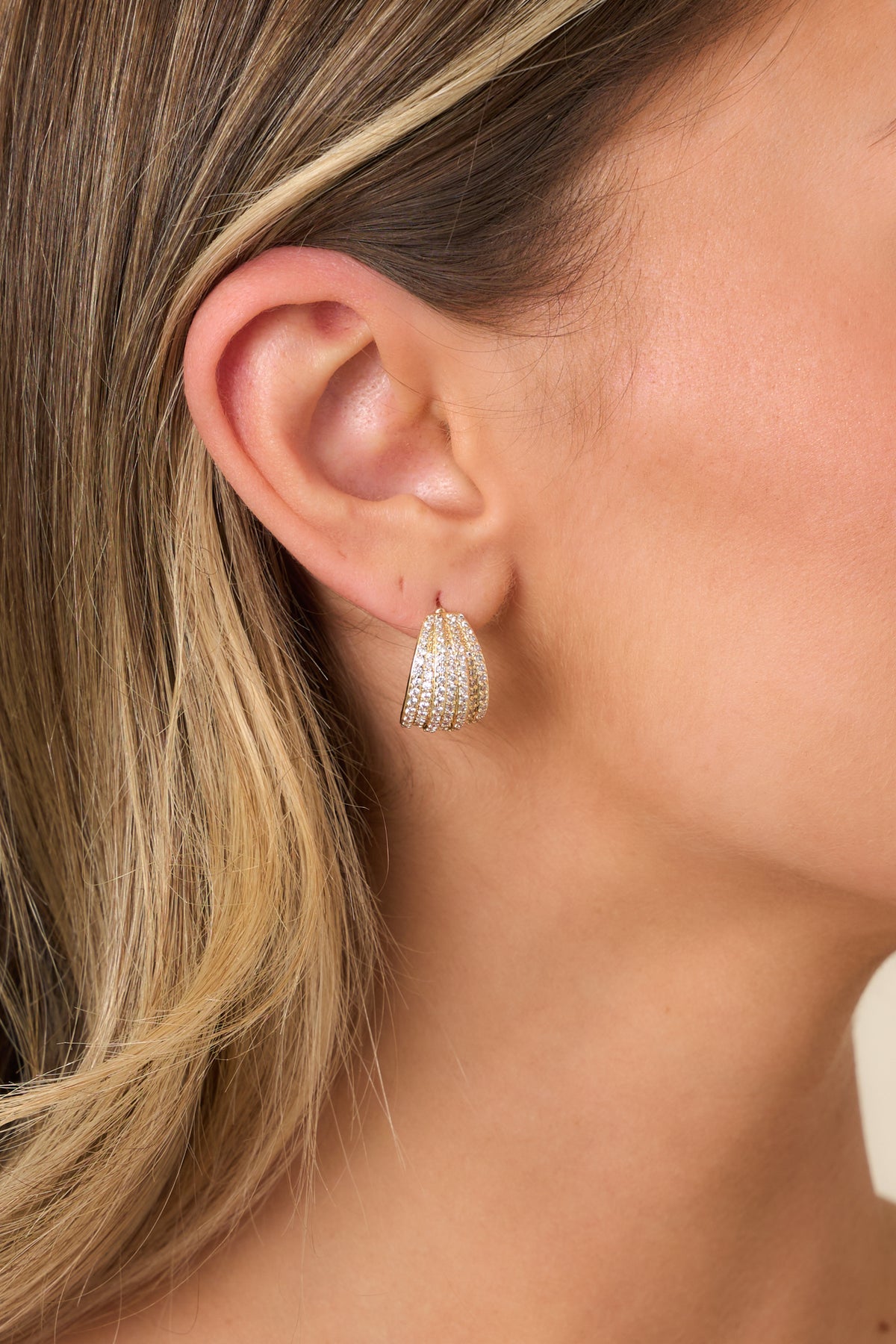 Curved statement earrings featuring rows of sparkling cubic zirconia with gold-dipped accents.