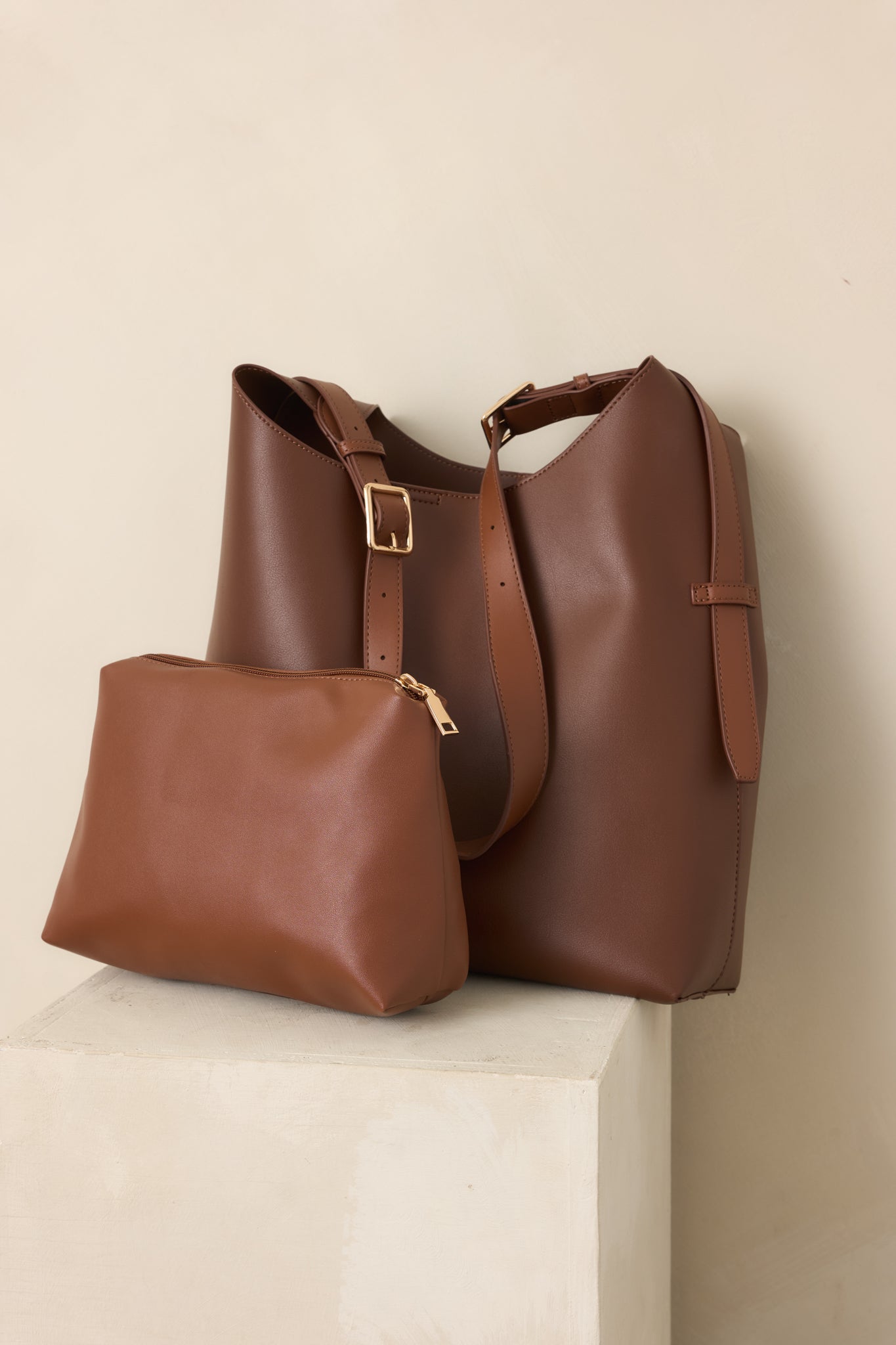 Close view of the dark brown handbag highlighting the adjustable shoulder strap and clean minimalist construction.
