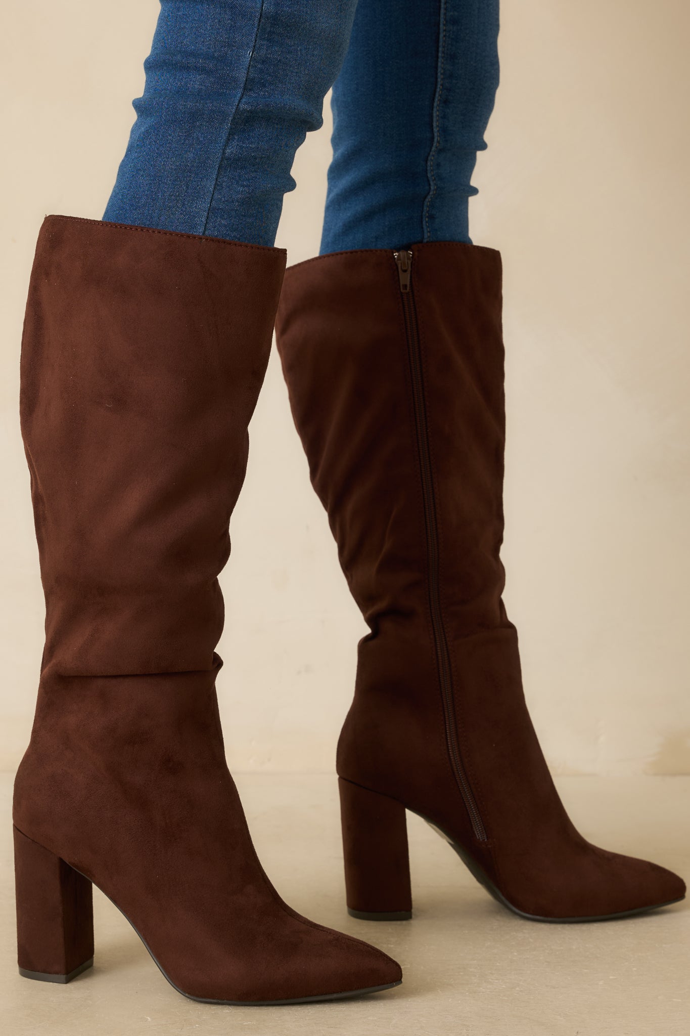 Dark brown faux suede knee-high boot with pointed toe and tall block heel.