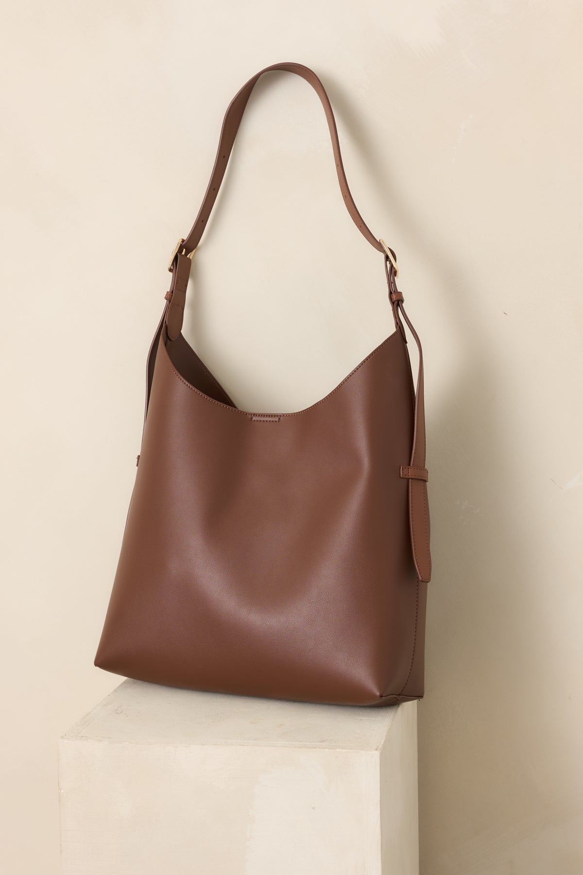 Dark brown carryall showcasing the magnetic tab closure, spacious opening, and polished streamlined silhouette.