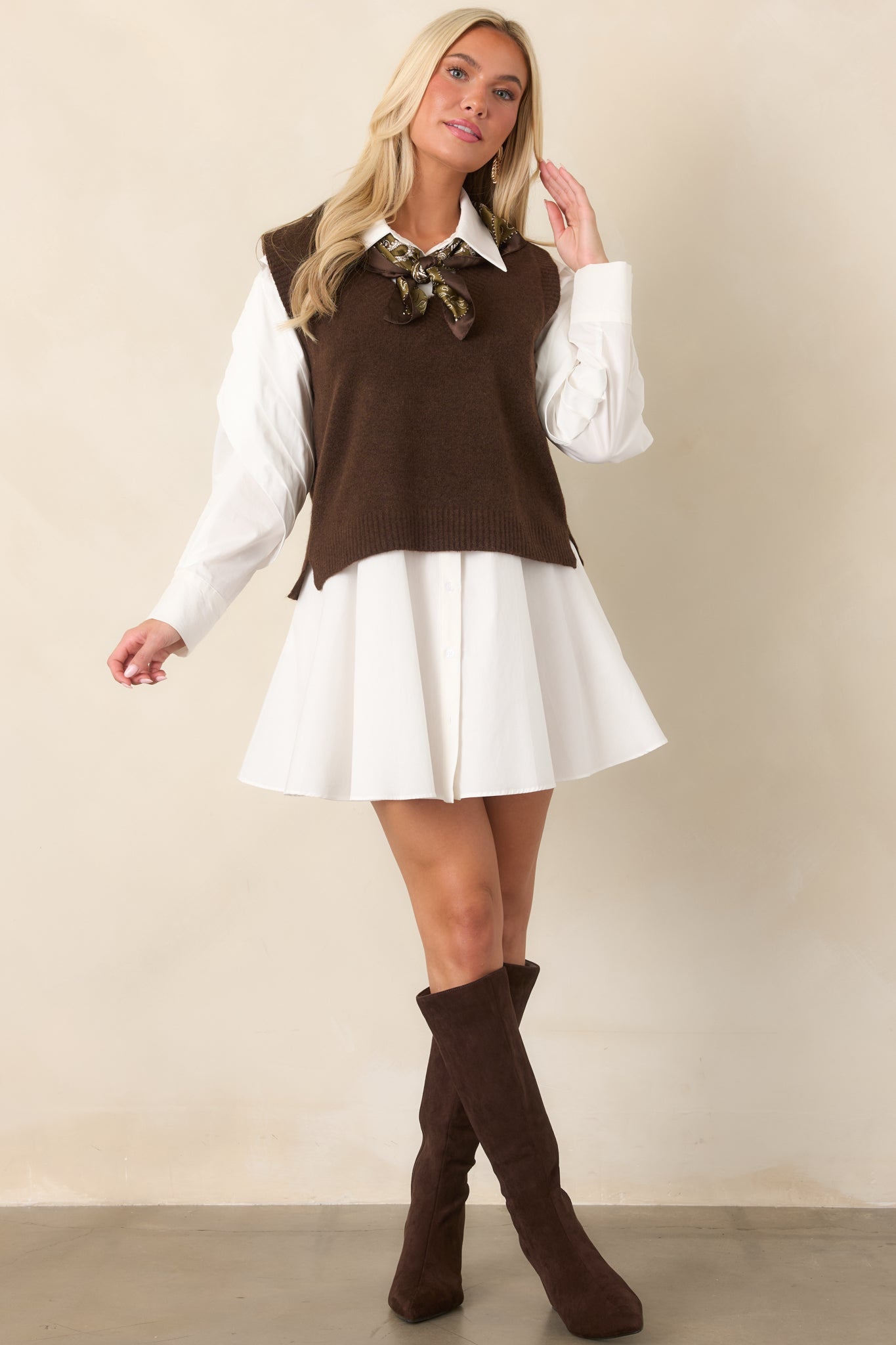 Dark chocolate sleeveless vest with a V-neckline framed by wide ribbed trim and small side slits at the hem.