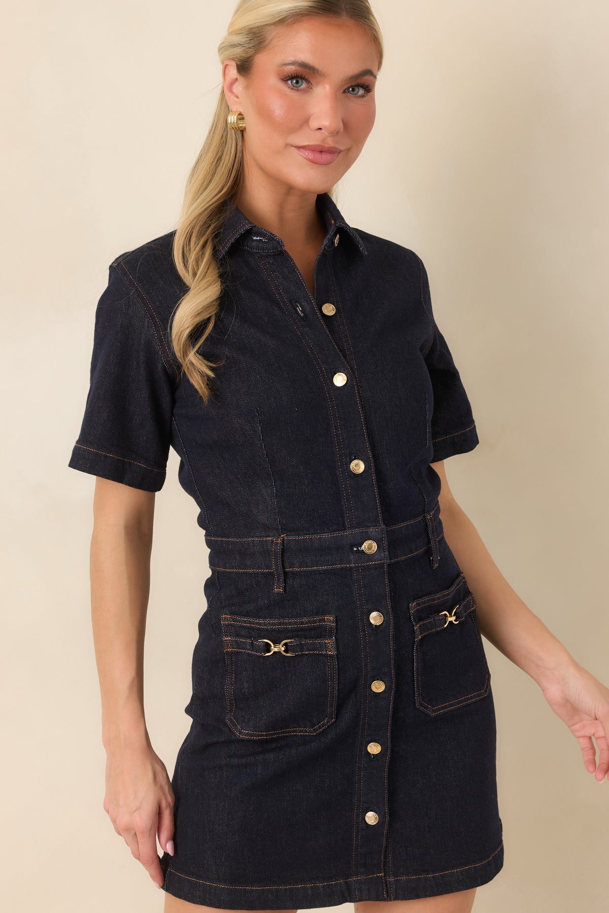 Fitted waist shapes the silhouette of this dark denim mini dress with short sleeves and a collared neckline.