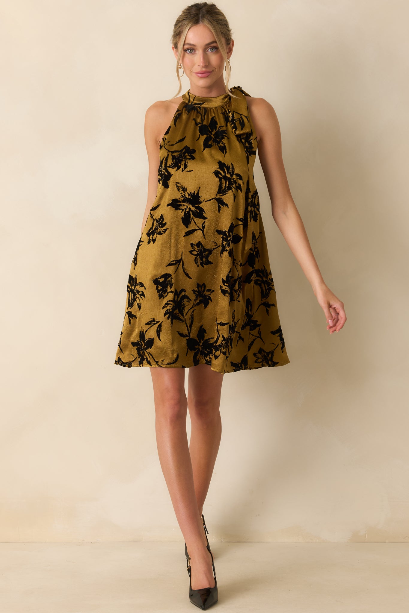 Dark gold satin dress showing a polished A-line fit and halter neckline accentuated with a side bow.