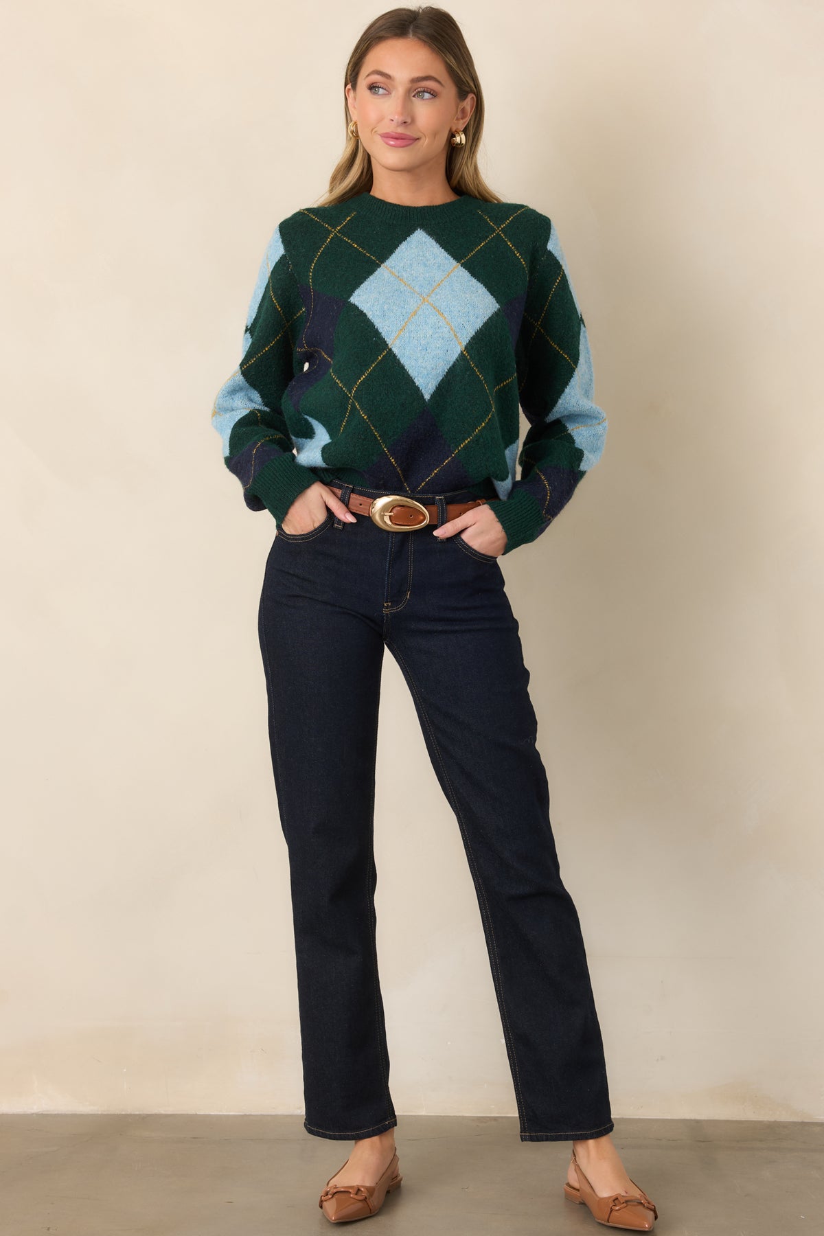 Dark green knit sweater featuring a classic diamond pattern in light blue and navy, fine golden yellow lines, crew neckline, and relaxed fit.