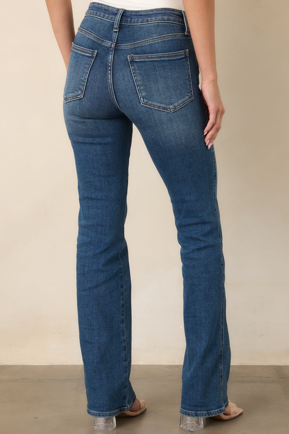 Rear view of the dark indigo bootcut jeans, highlighting the fitted hips and thighs, belt loops, and classic back pockets.