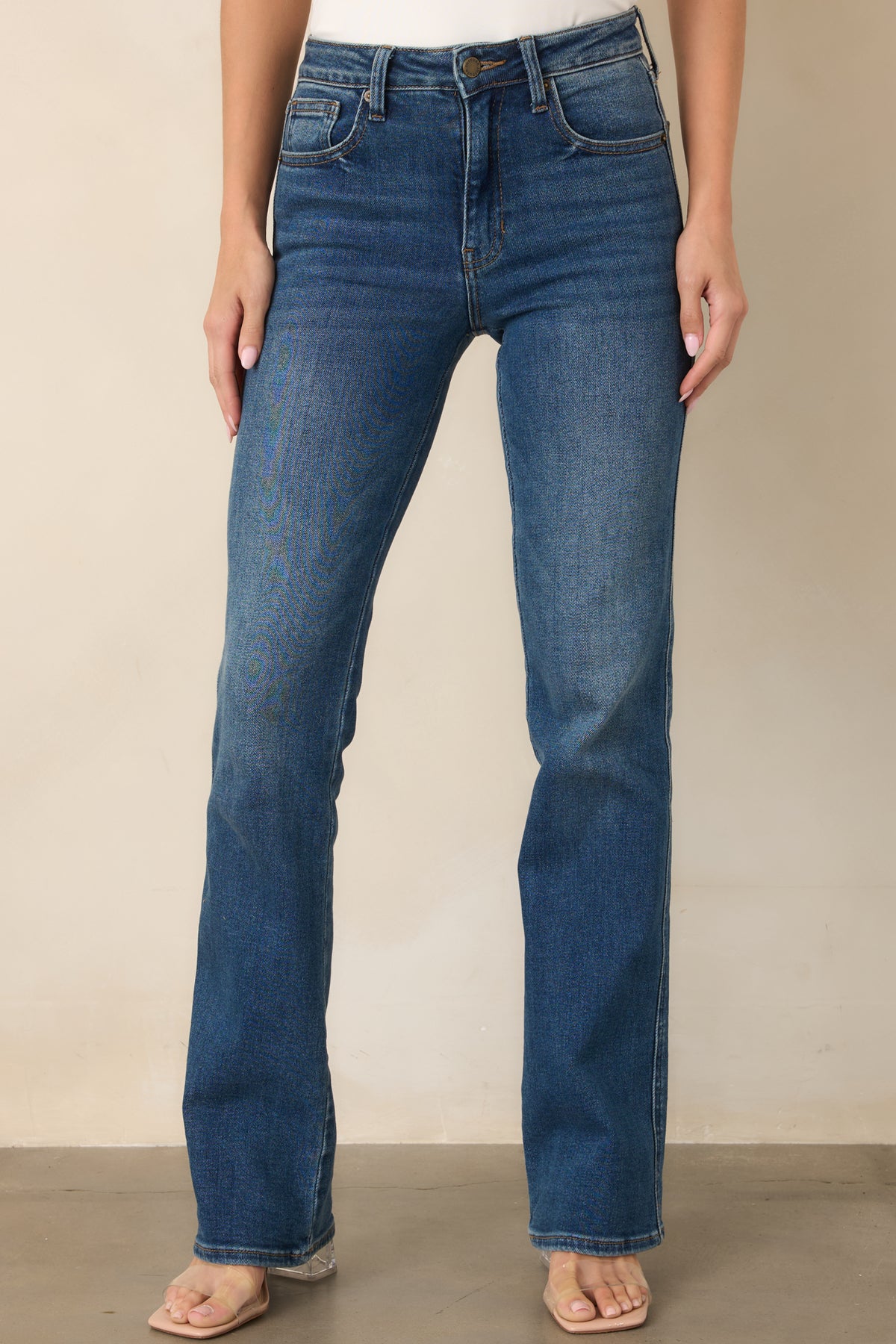 Dark indigo bootcut jeans featuring classic five-pocket styling and a fitted silhouette that transitions into gently flared legs.