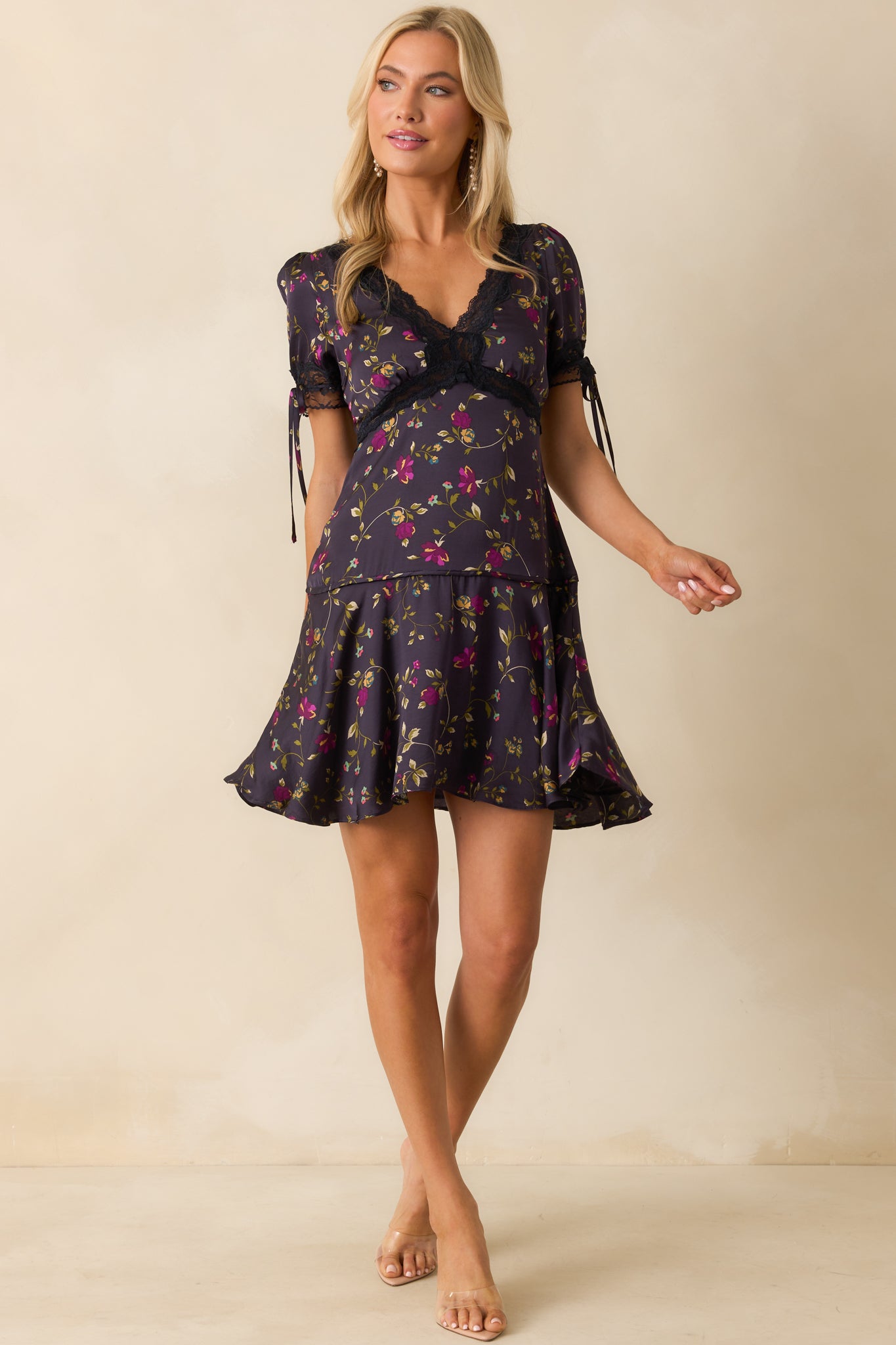 A front view of the dark indigo mini dress with purple multicolor floral print, deep v-neckline with navy lace trim, and flared skirt.