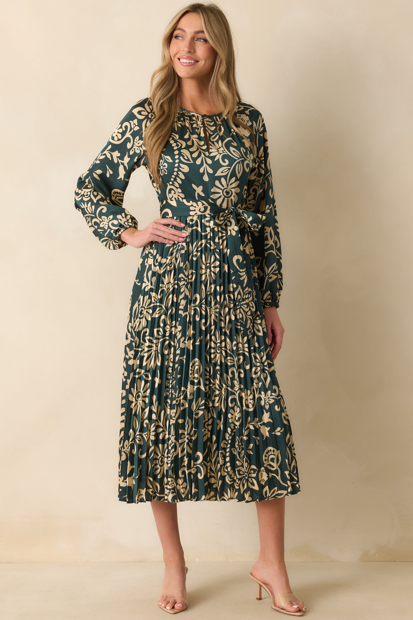 Dark teal dress decorated with beige floral print and round neckline.