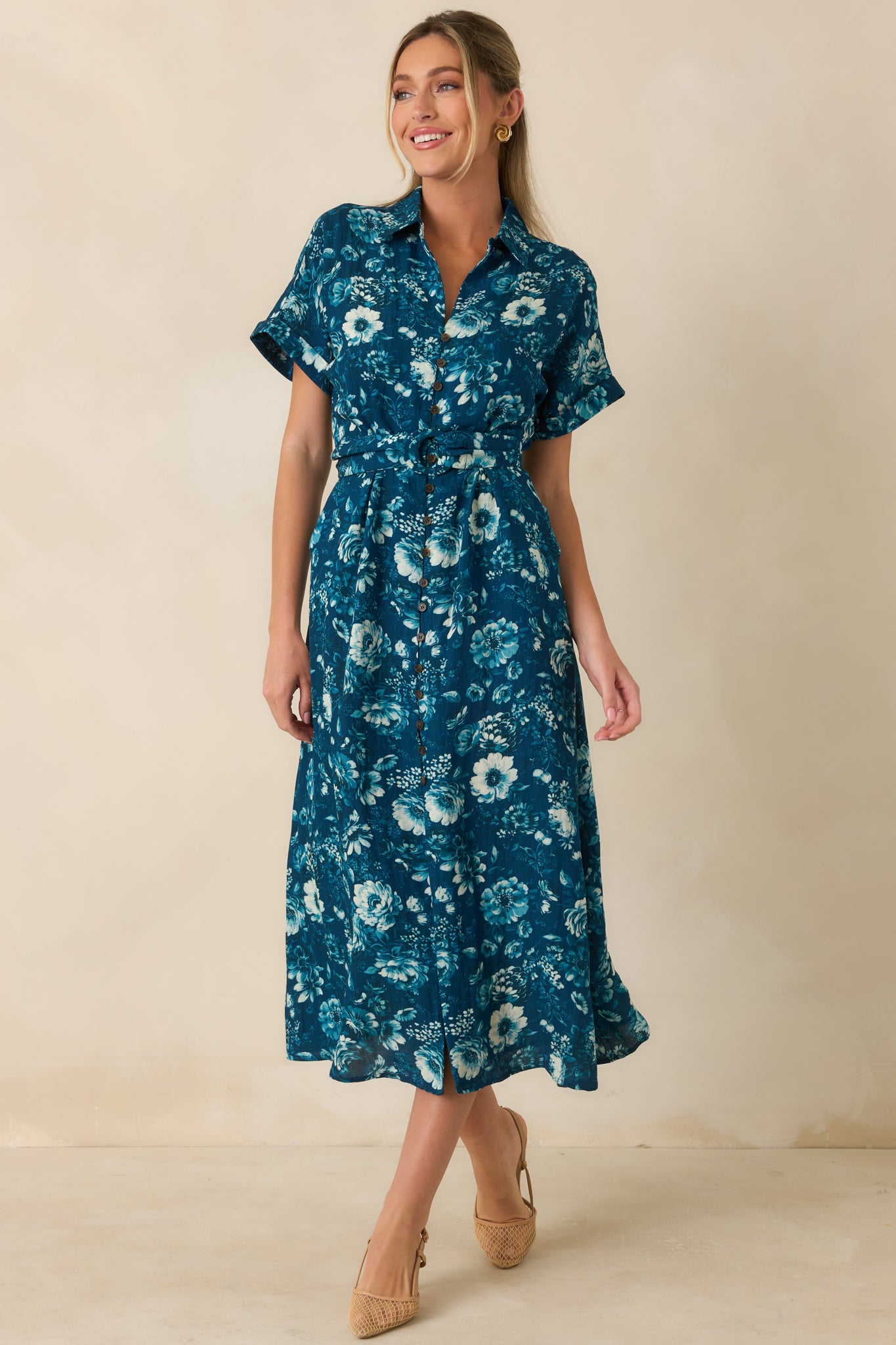 Dark teal midi dress with vibrant floral pattern, collared neckline, short sleeves, and cinched waist.