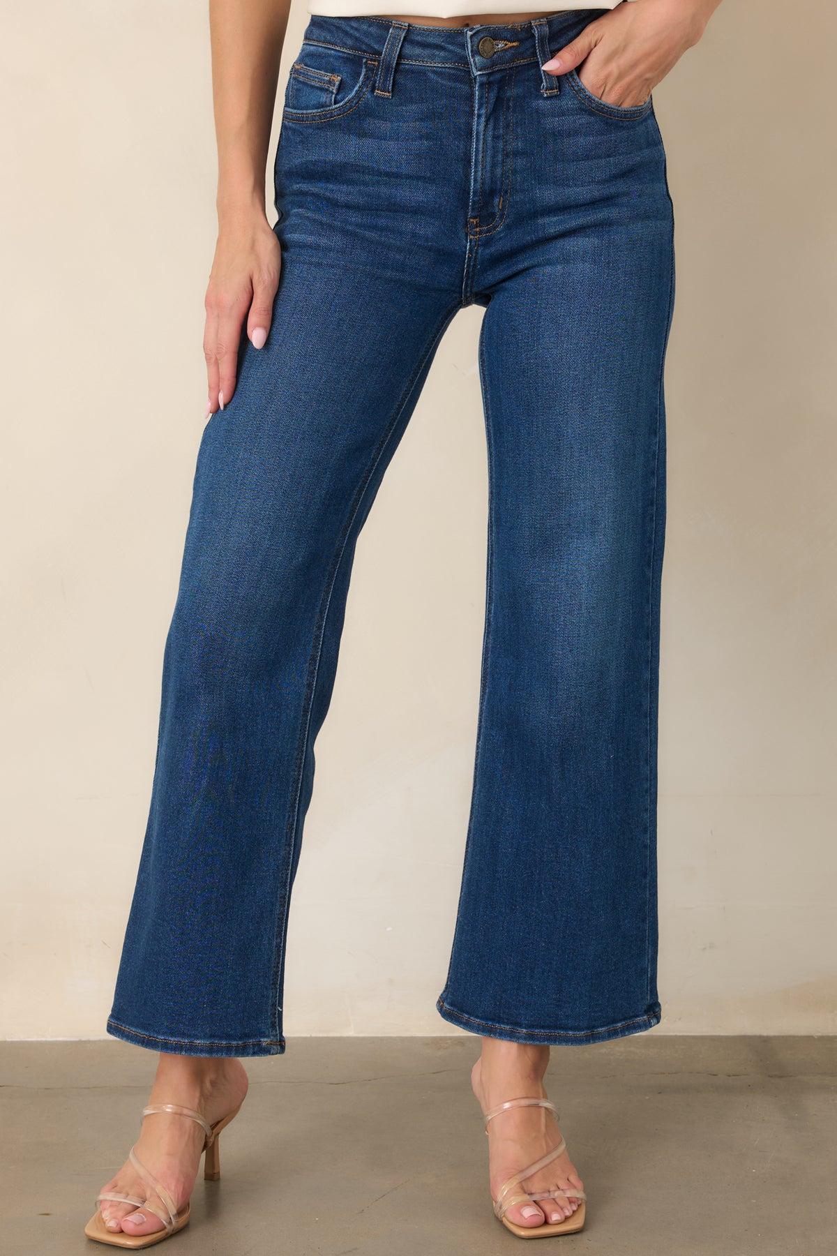 Detailed view of the cropped dark wash denim, emphasizing the relaxed leg shape and neatly finished hem.