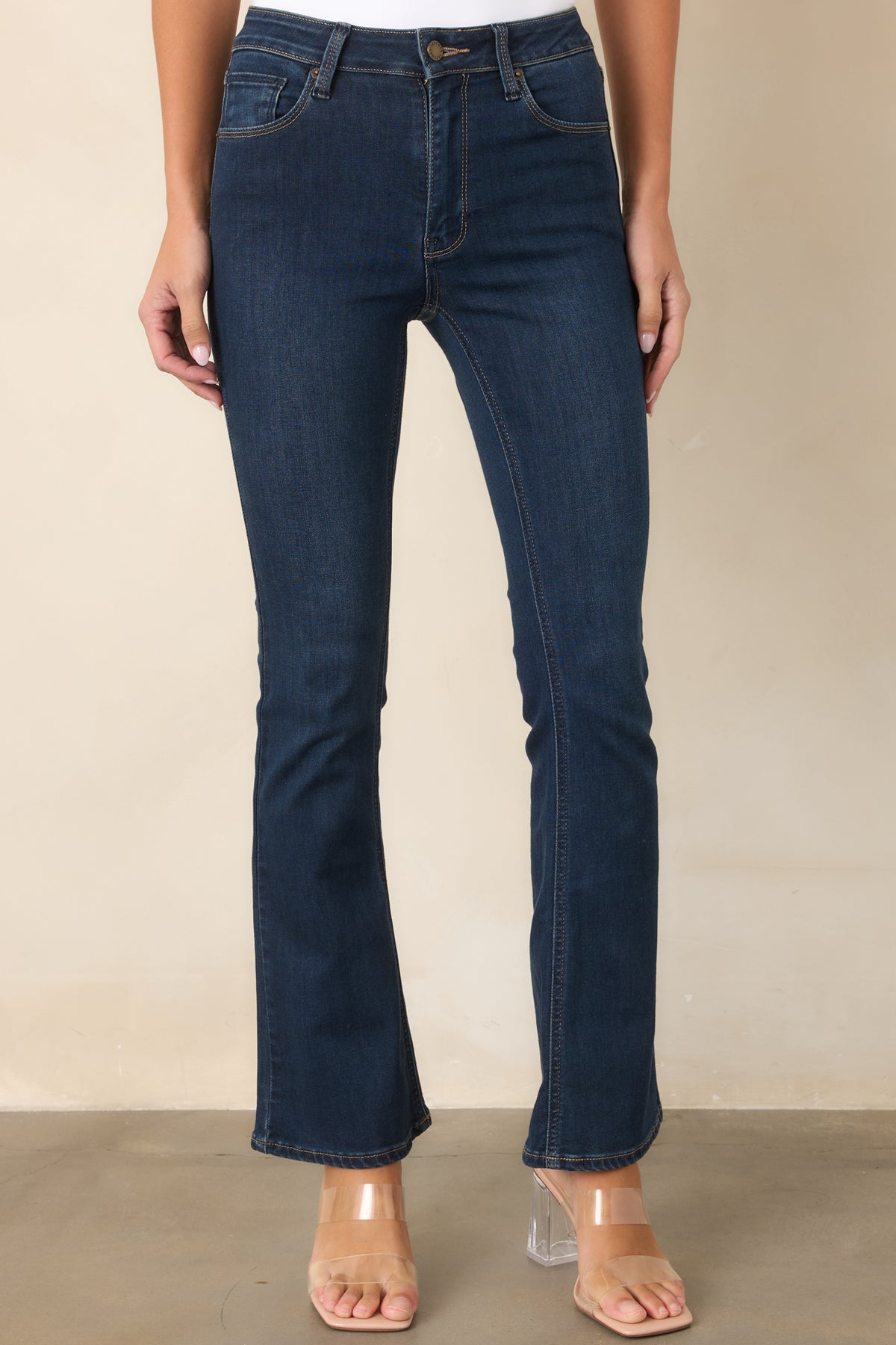Dark wash jeans showcasing the high-rise waist, front closure, and classic five-pocket design.