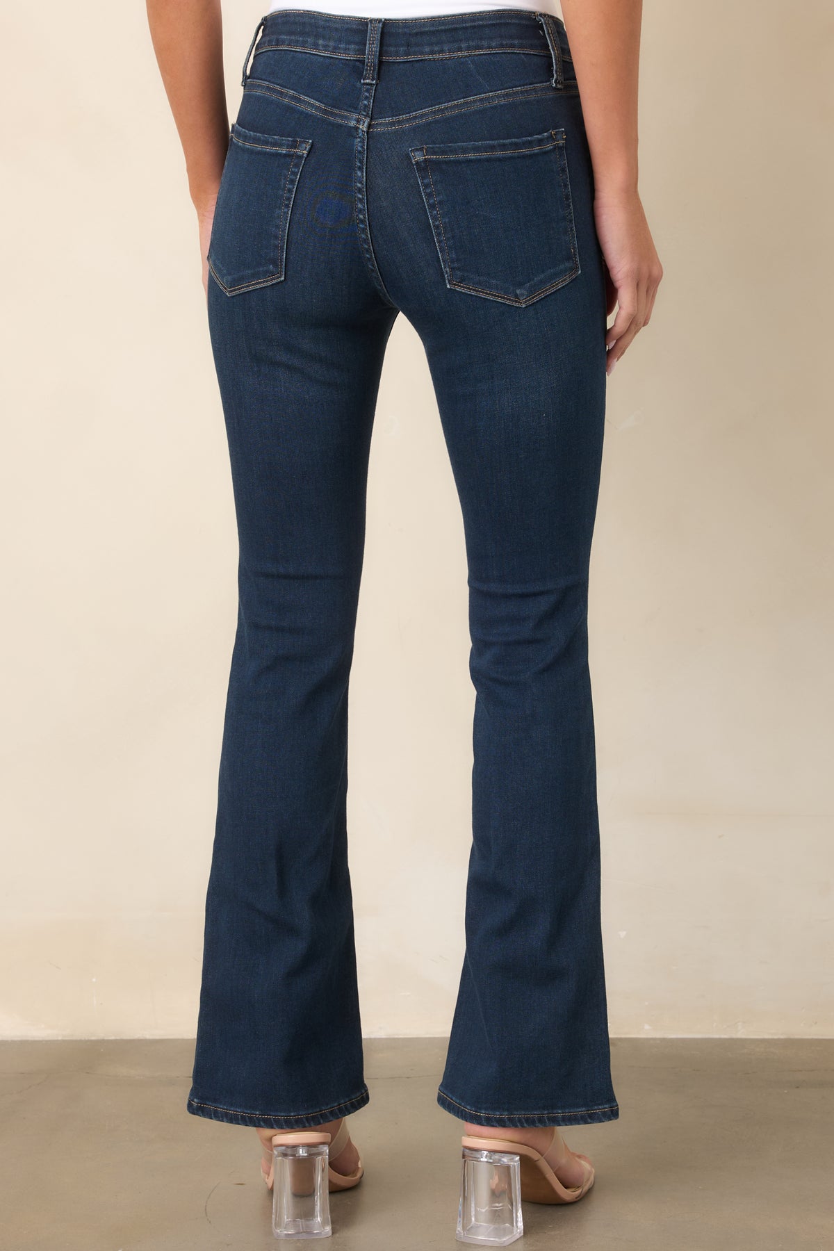 Rear view of the dark wash jeans showing the high-rise waist, back pockets, and slight flare leg.