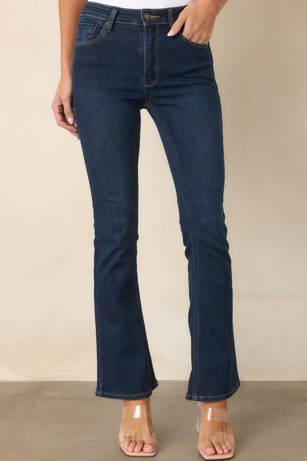 Dark wash stretch jeans featuring a smooth high-rise waistband and slight flare silhouette.