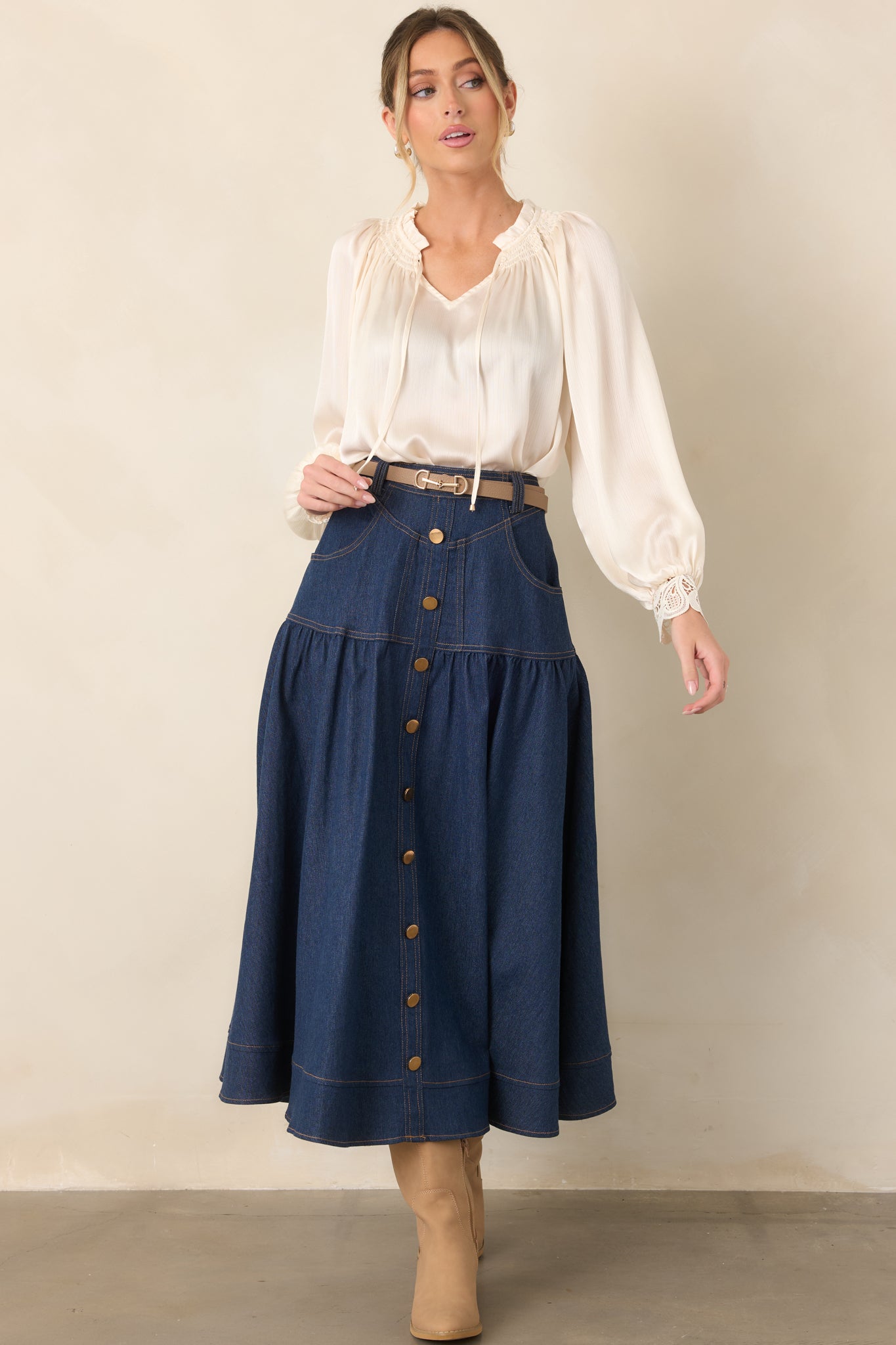 Dark wash denim maxi skirt with a structured high-rise waistband, gold-tone button front, functional pockets, subtle flare, and wide hem.