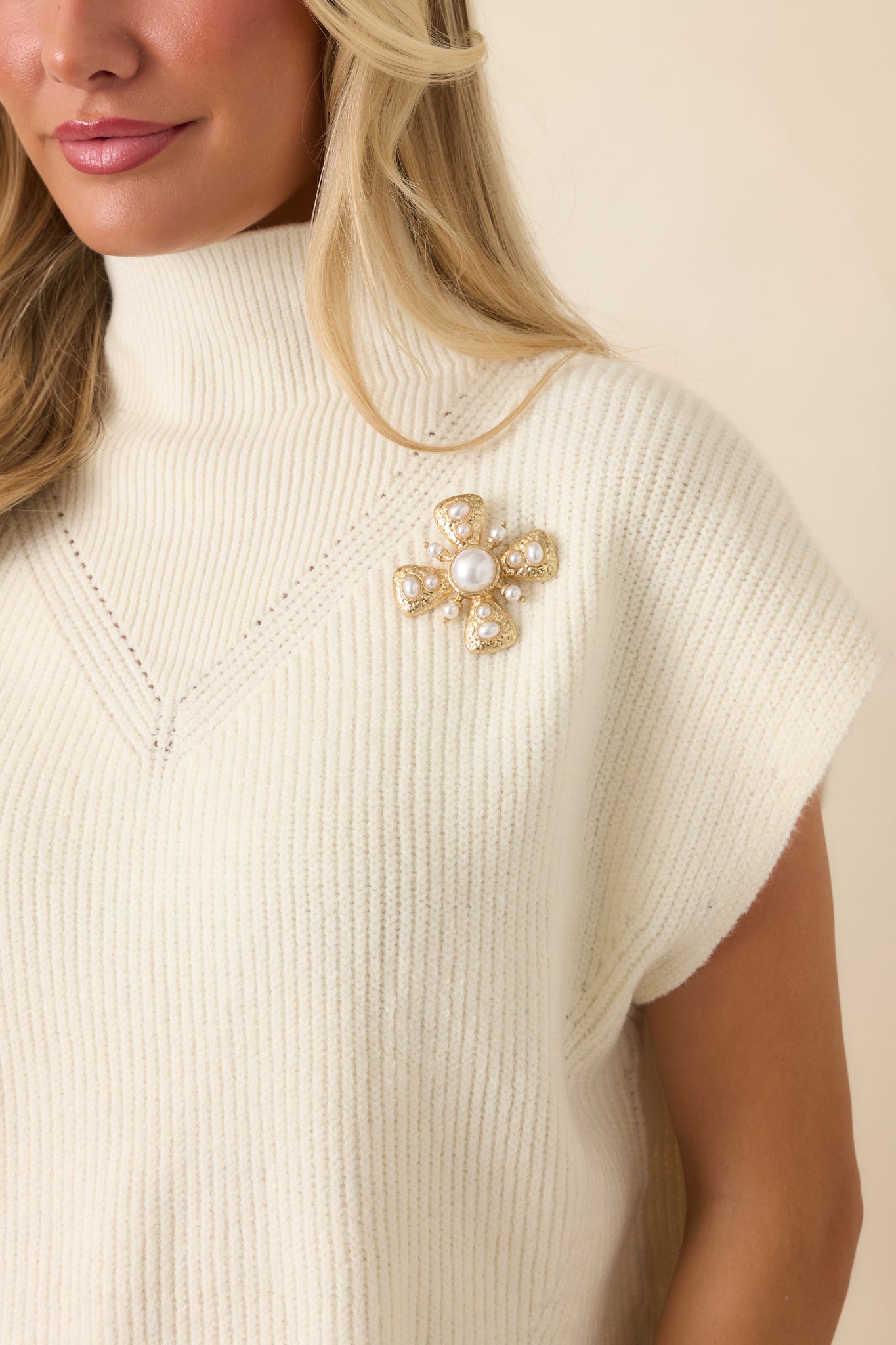Decorative gold brooch showcasing a statement silhouette with multiple pearl embellishments, detailed metalwork, and an elegant finish.