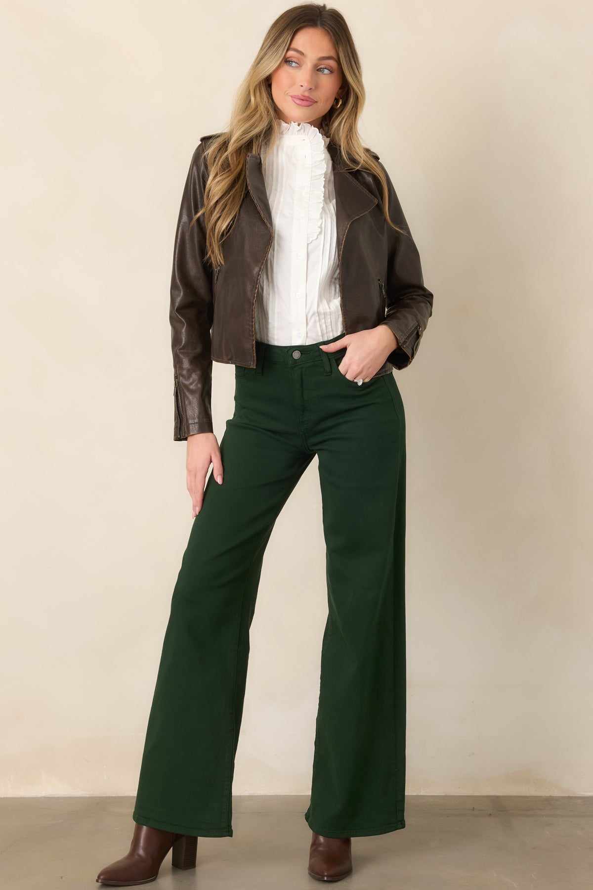Deep forest green jeans with a high-rise fit, flowing wide legs, and versatile polished appearance.