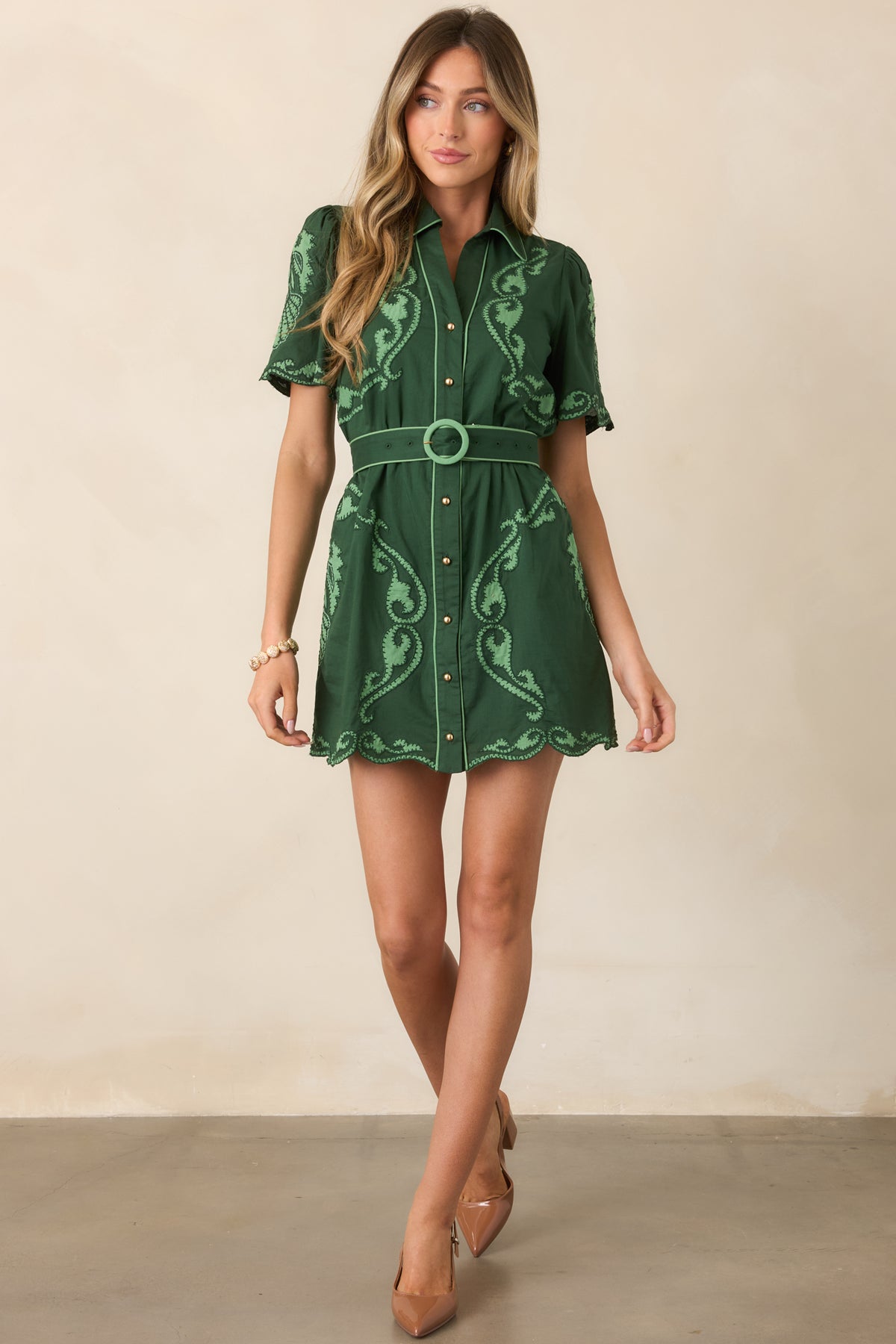 Deep green cotton mini dress featuring light green scrollwork, a pointed collar, and defined waist.