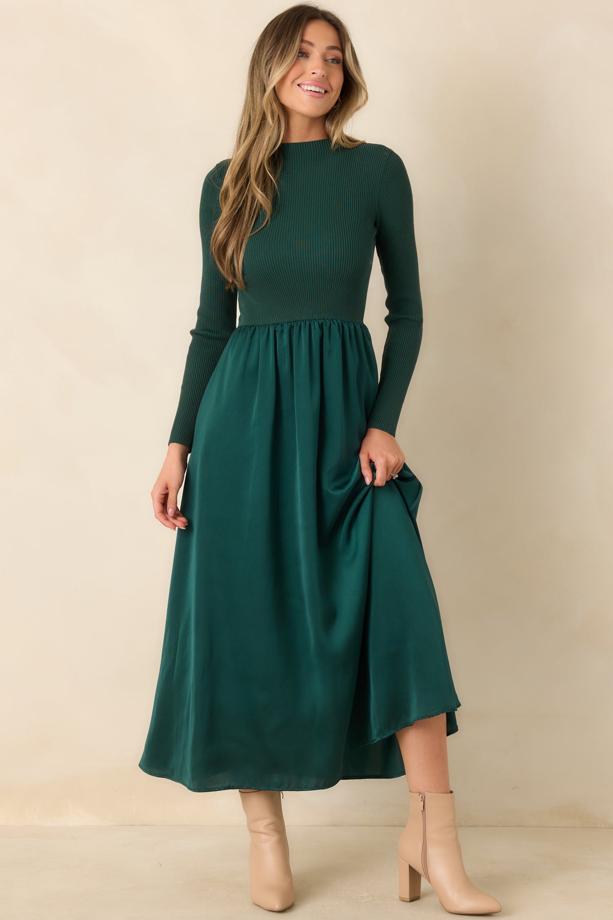 Deep green fit-and-flare dress featuring a textured knit top and softly gathered satin waist.