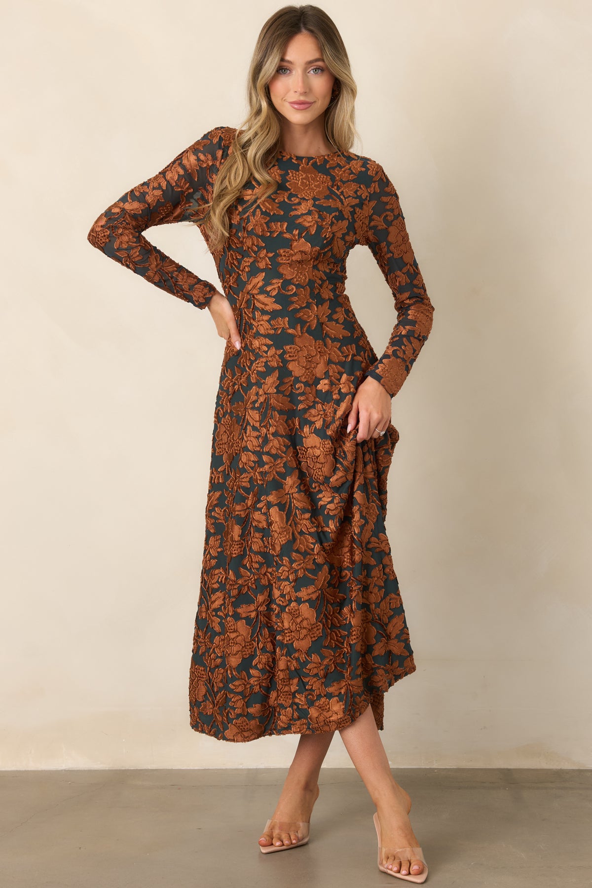 Deep green midi dress showcasing raised copper floral detailing, a fitted waist, and a graceful flowing silhouette.