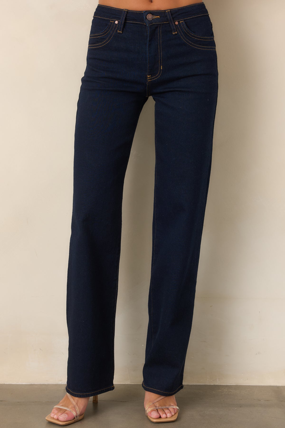 Deep indigo jeans showcasing the structured waistband and classic five-pocket design.